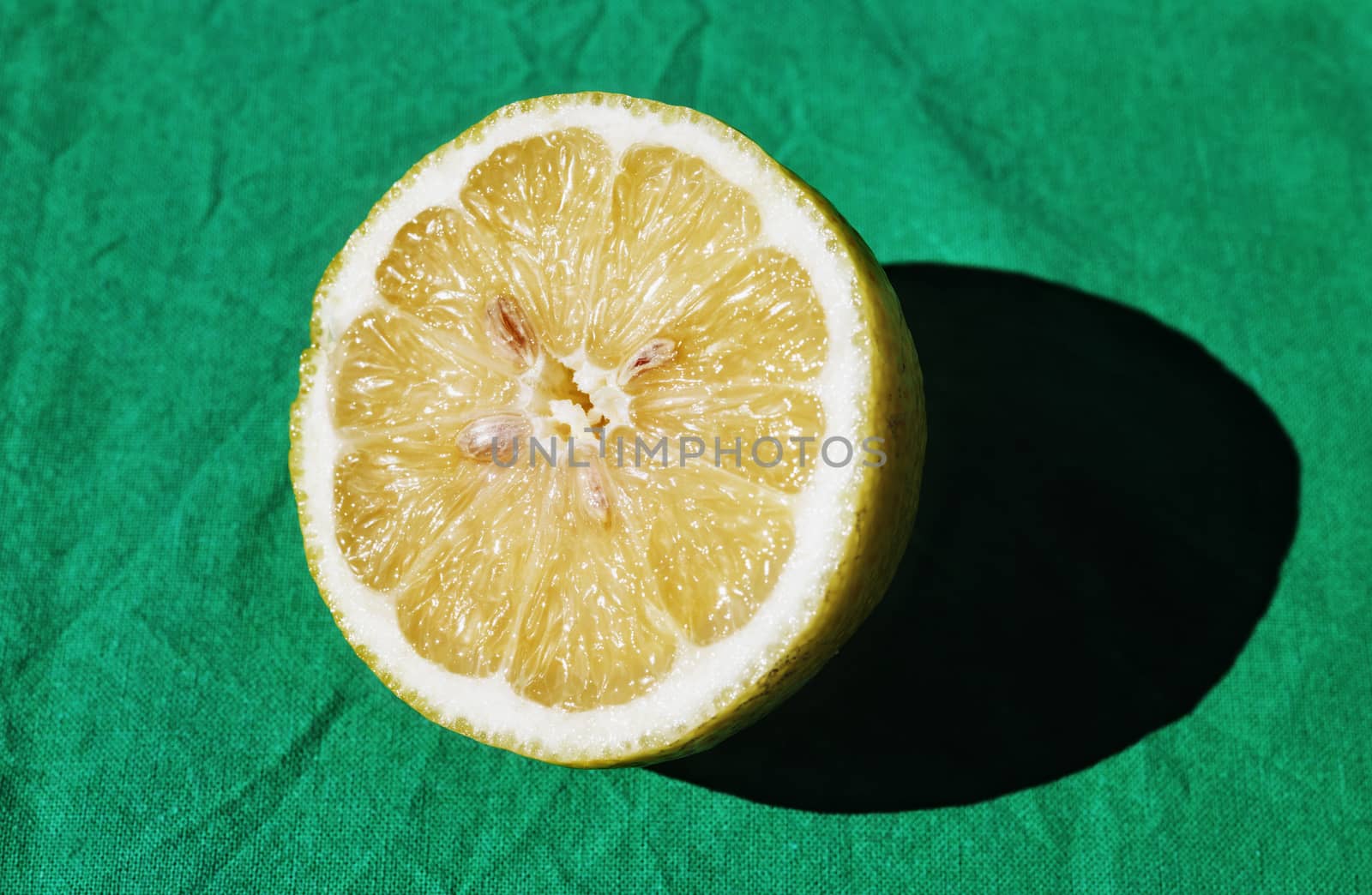 Beautiful sliced lemon on green cloth, light and shadow ,studio shot 