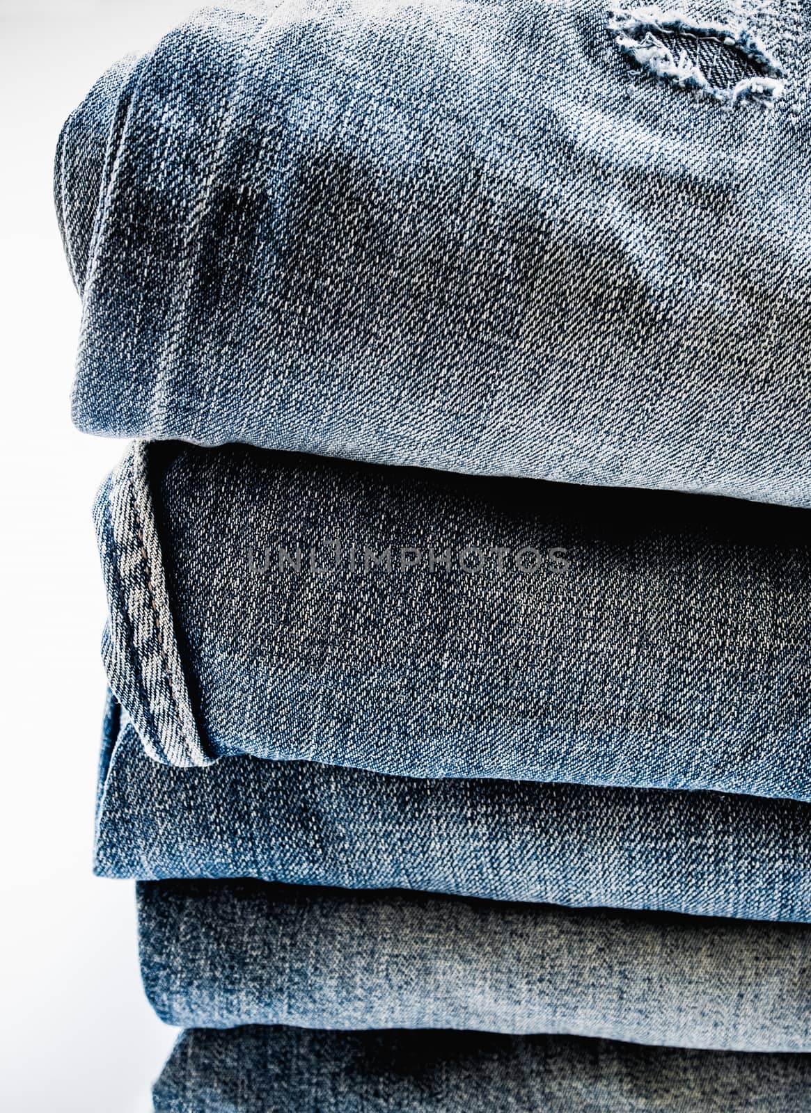 Pile of different blue jeans, fabric texture