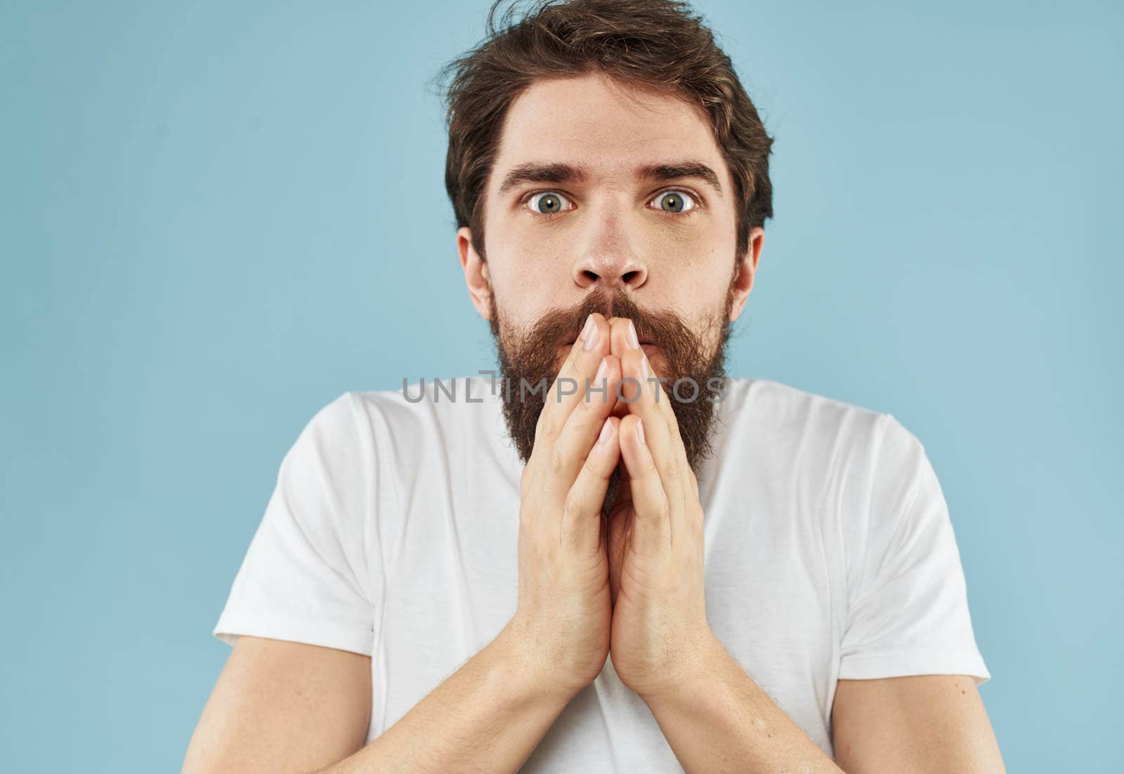 Puzzled man with a beard on a blue background emotions of surprise. High quality photo