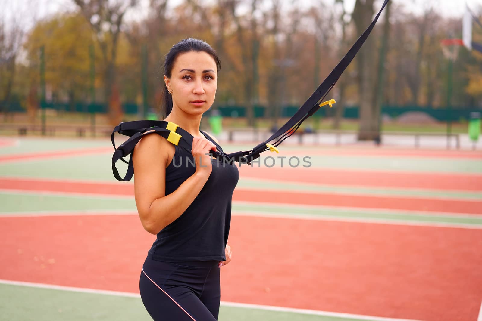 Girl athlete training using trx sportground Mixed race young adult woman workout suspension system Healthy lifestyle Stretching outdoors playground. Make your body machine