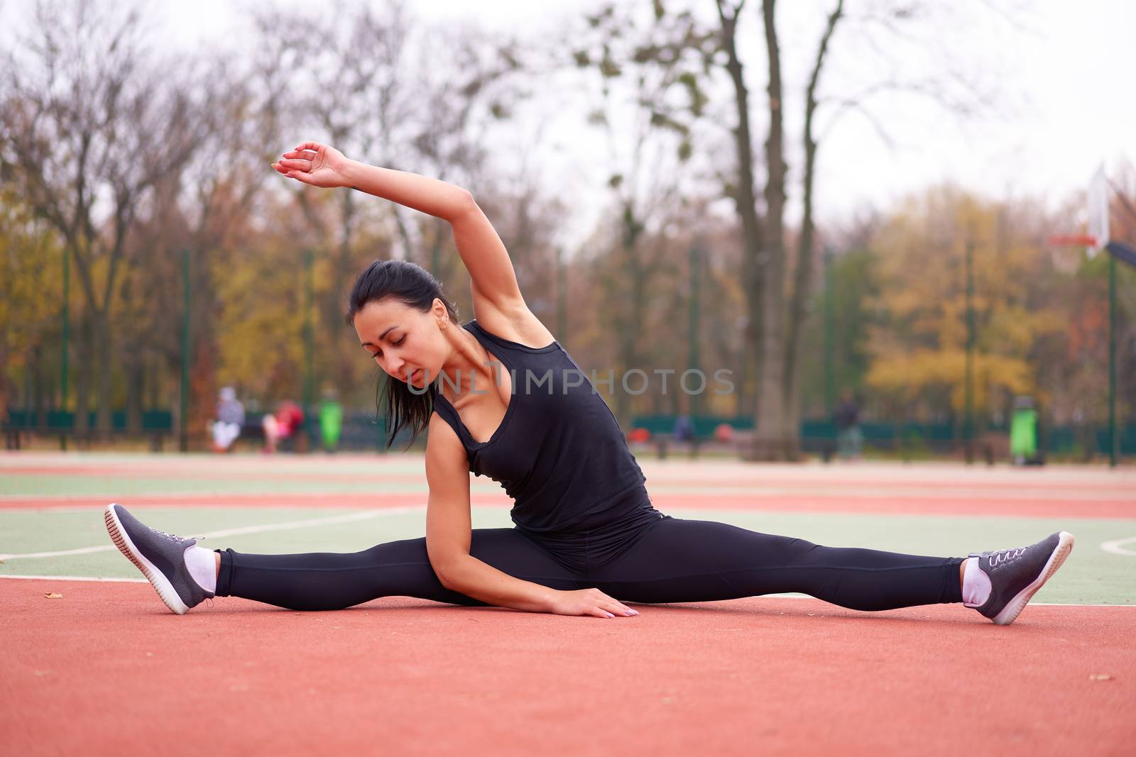 Happy girl doing fitness exercises outdoor on playground. Healthy lifestyle. Morning workout positive emotion smiling sportive people. one female training stretching