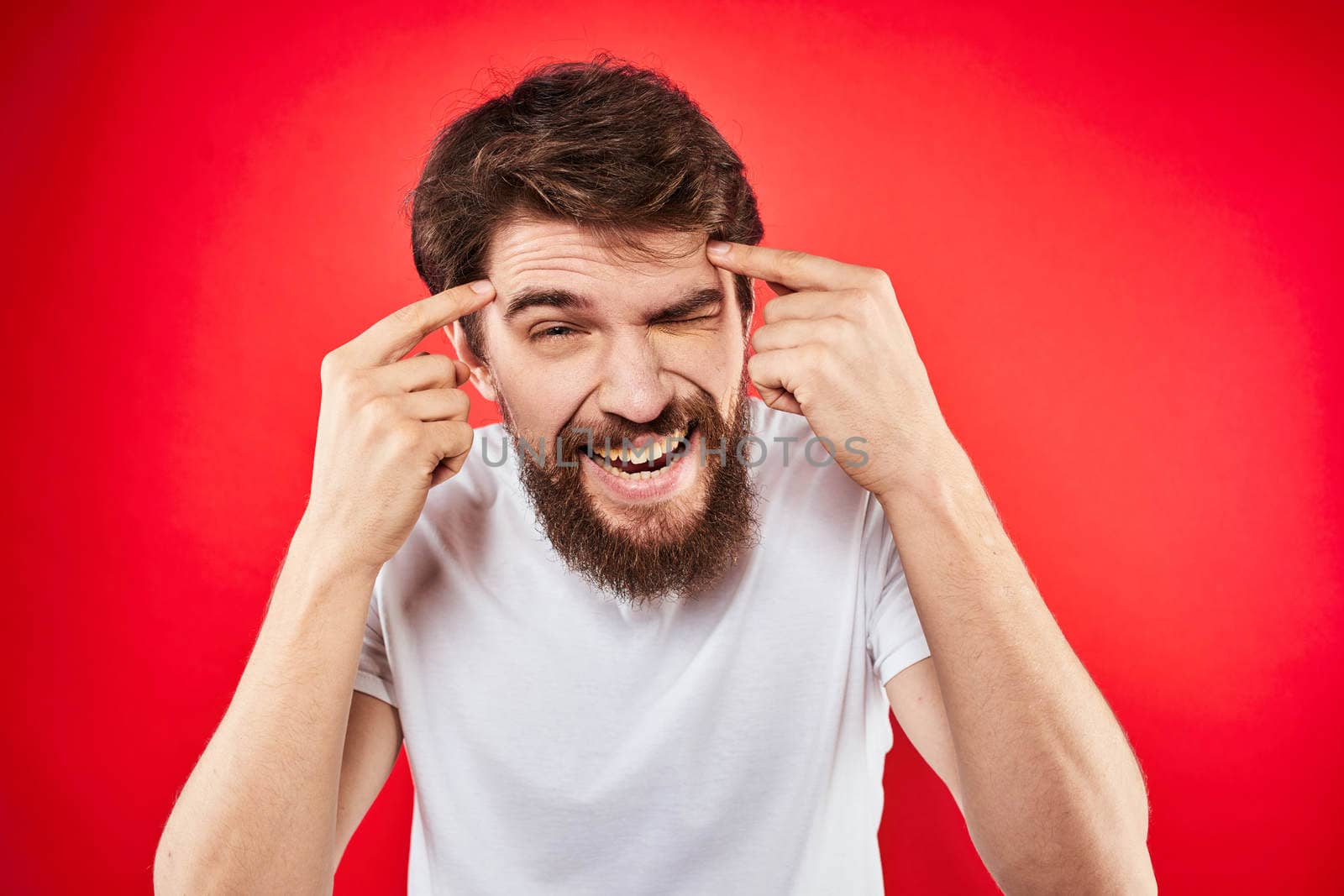 Bearded man fun emotions lifestyle cropped view white t-shirt red background. High quality photo