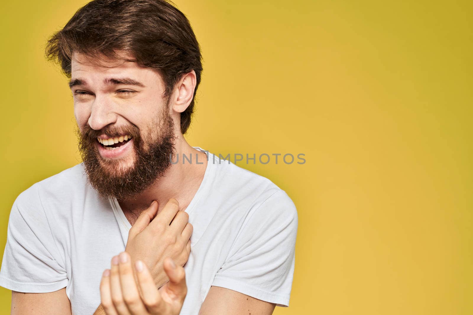 Bearded man in white t-shirt emotions close-up fun yellow background. High quality photo