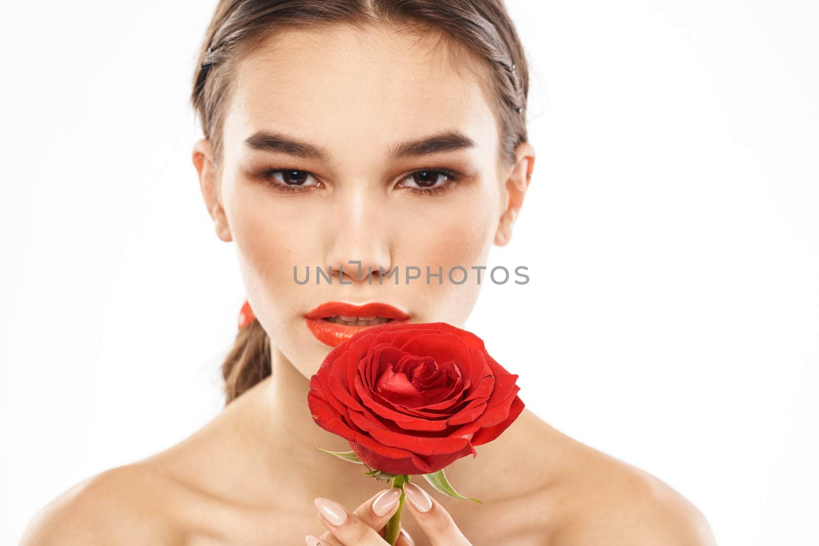 charming brunette girl with makeup on her face and a red rose in her hand. High quality photo