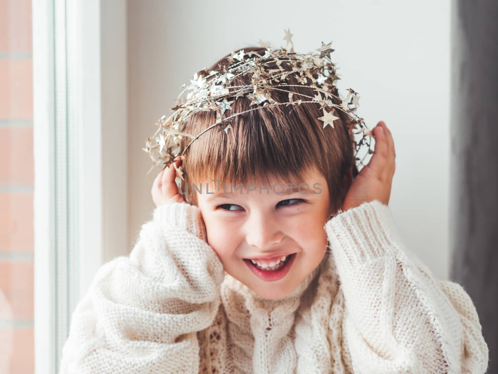 Kid with decorative star tinsel for Christmas tree. Boy in cable by aksenovko