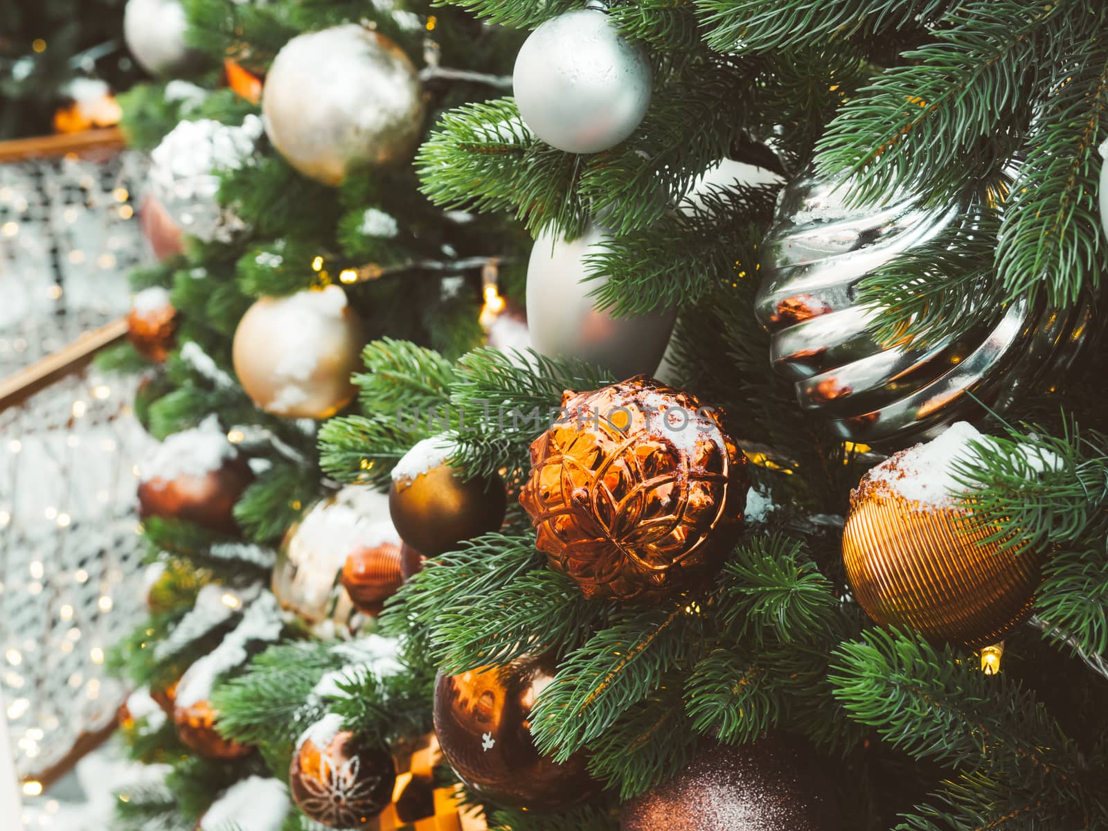 Christmas tree with silver and bronze balls. Outdoor decorations for New Year celebration.