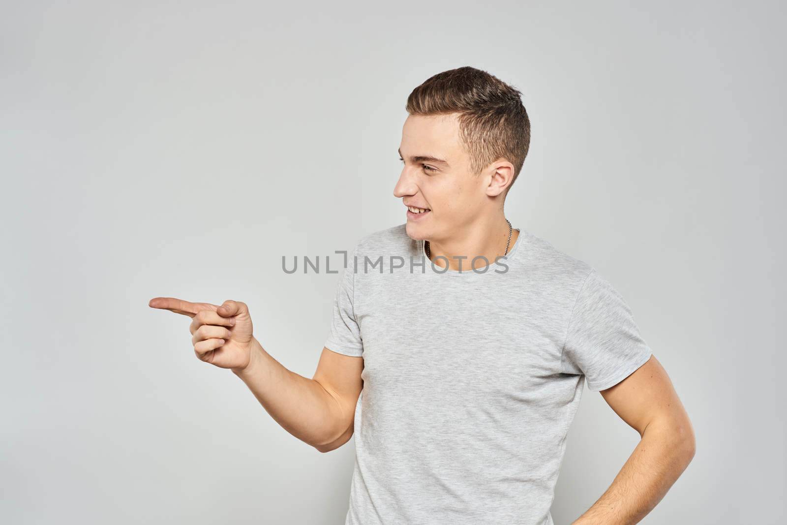 handsome man in light t-shirt cropped view emotion studio isolated background. High quality photo