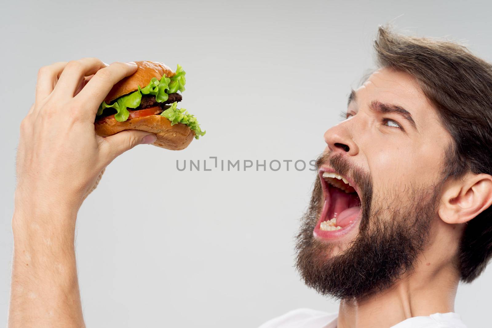 Man with hamburger fast food diet wide open mouth by SHOTPRIME