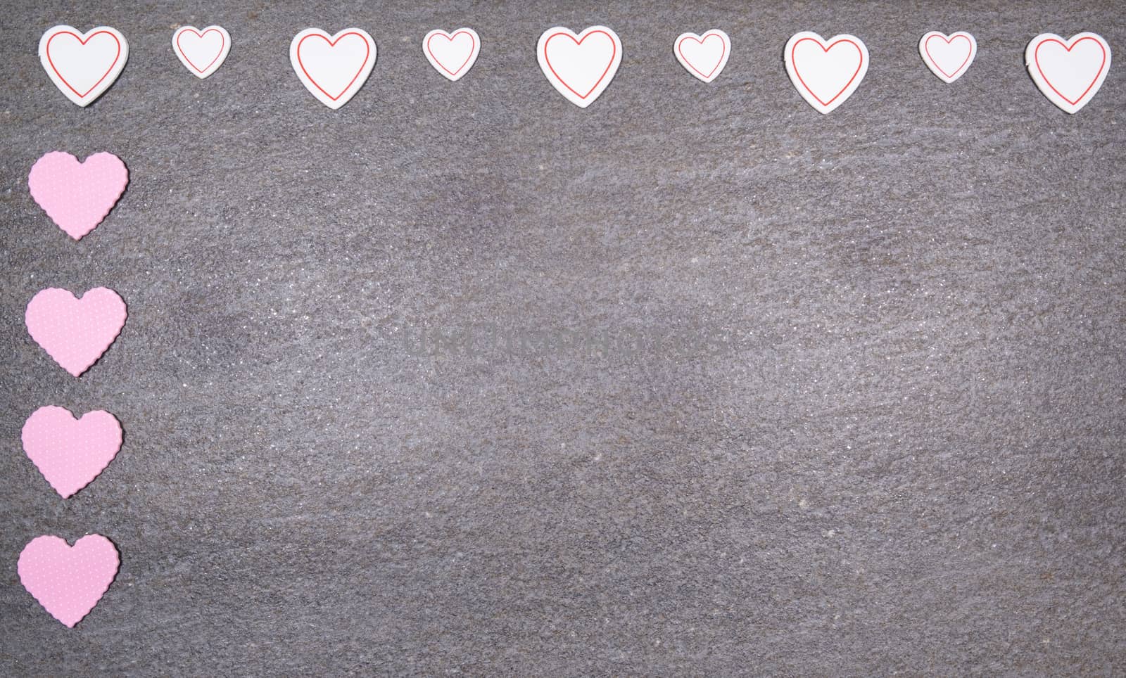 gray granite background with pink and white hearts for valentines day. Valentine's day and love concept.