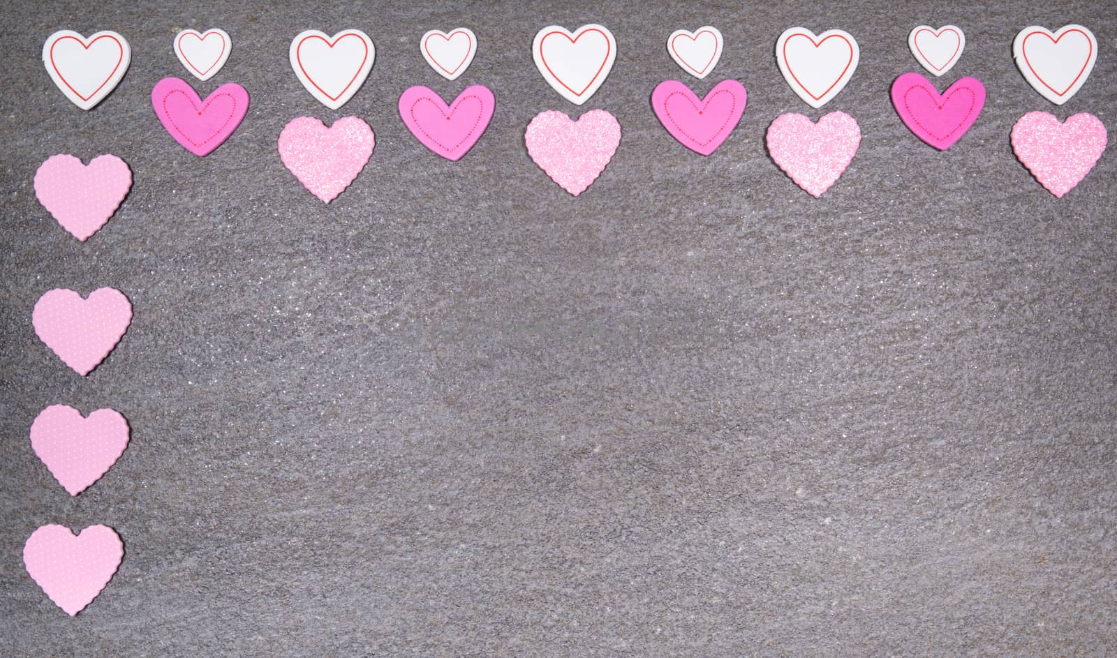 gray granite background with pink and white hearts for valentines day. Valentine's day and love concept.