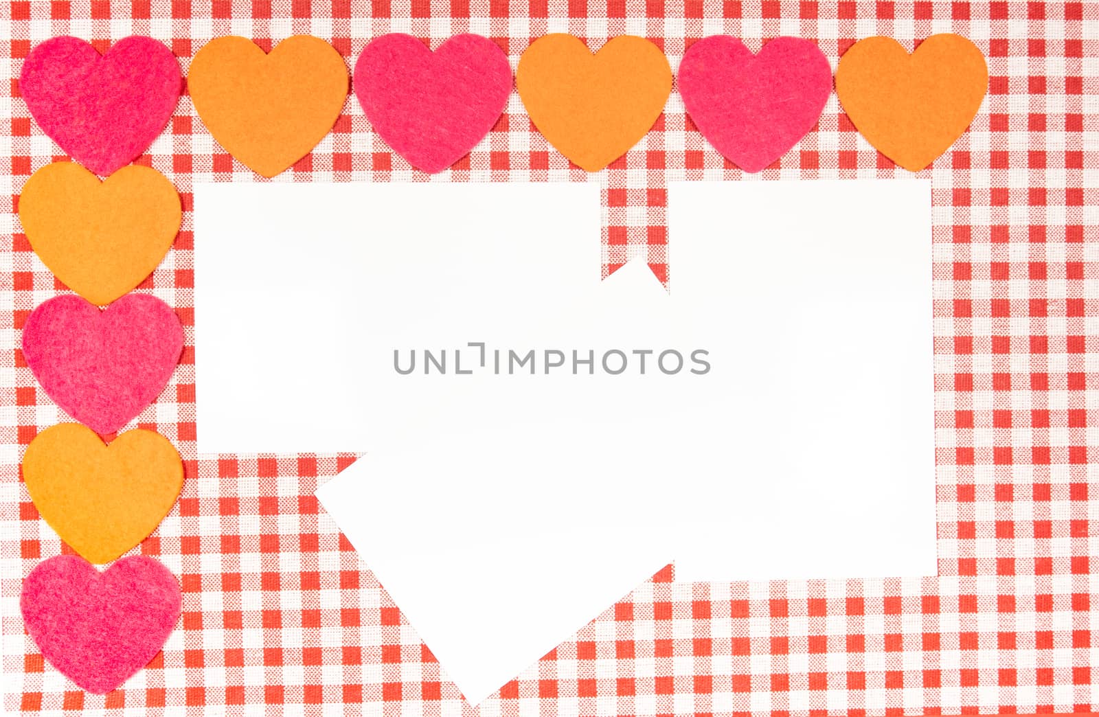 background with red and white Vichy fabric for valentine's day with red and pink hearts and a white card to put the text. valentines day concept