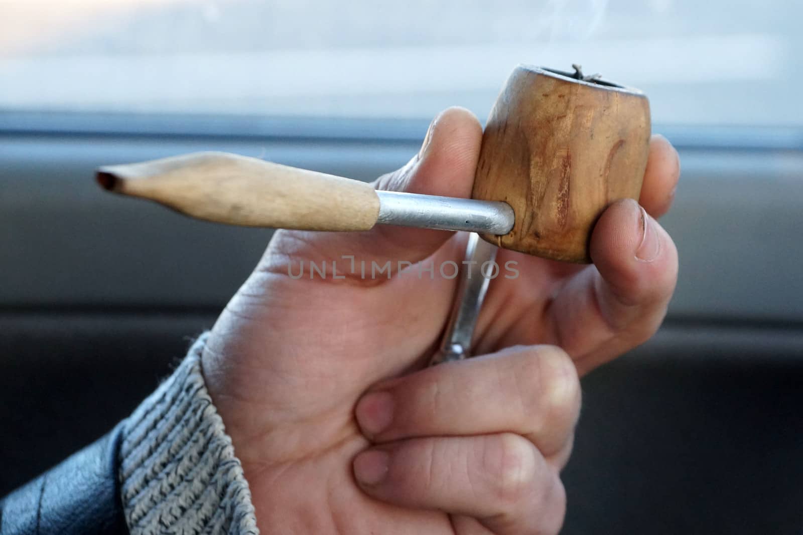 smoking pipe in male hand close up by Annado