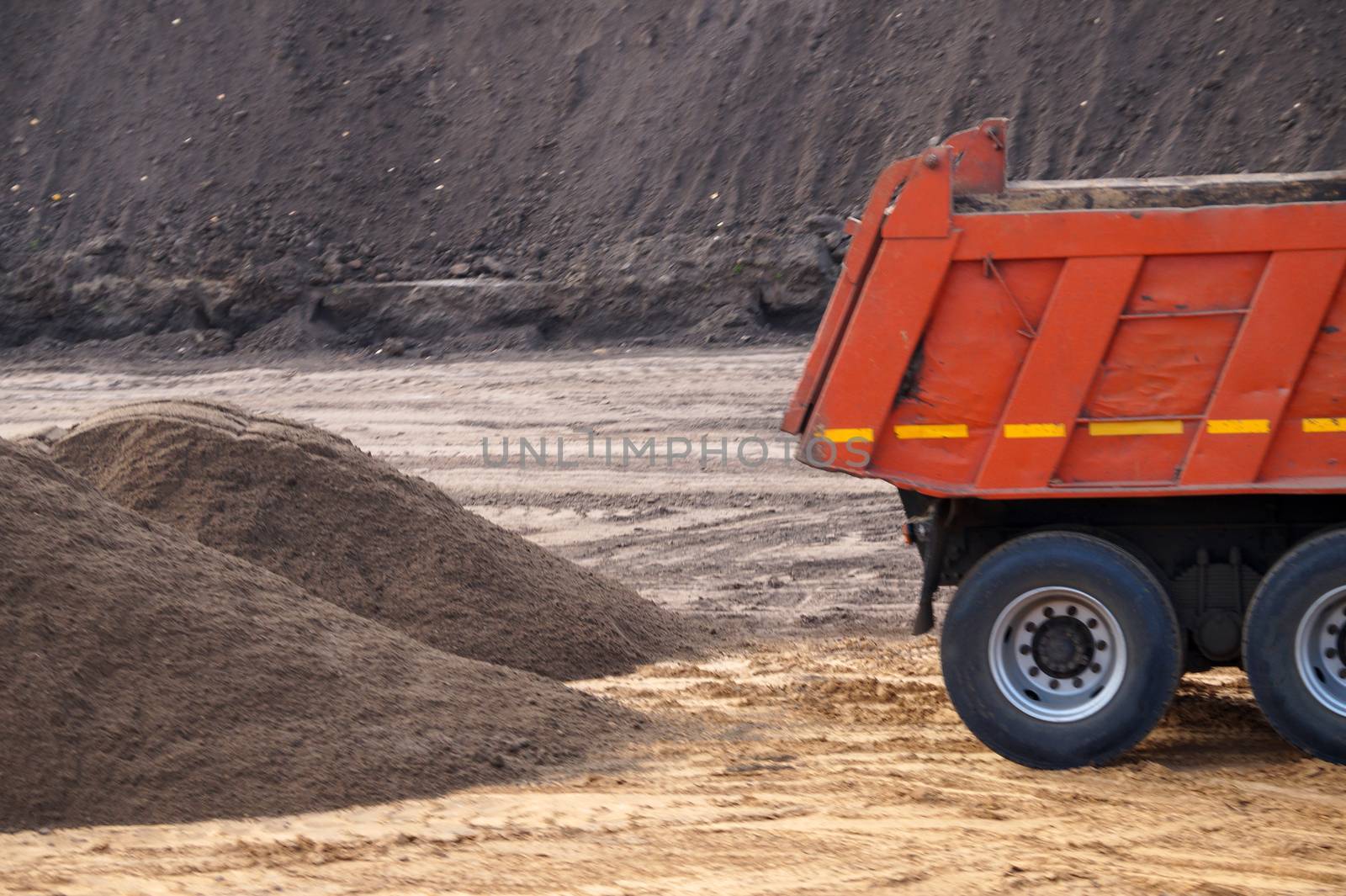 dump truck and a pile of sand at a construction site close-up