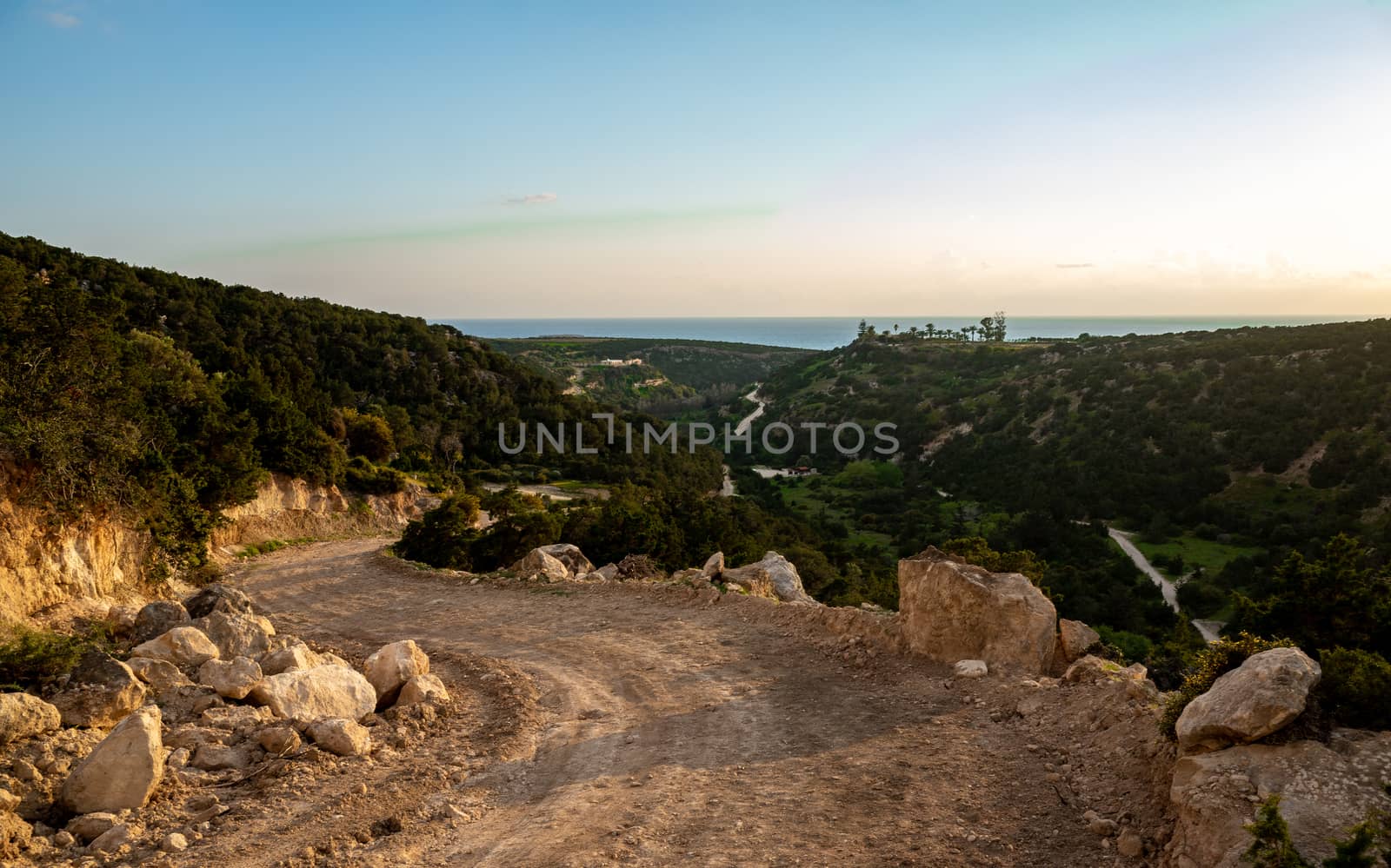 Sandy mountain road of the island of Cyprus in the light of the setting sun.