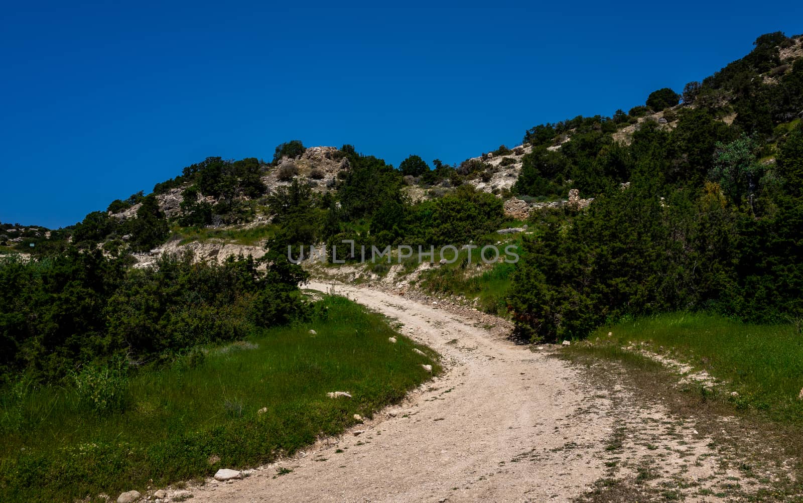 Sandy mountain road of the island of Cyprus in the light of the setting sun.