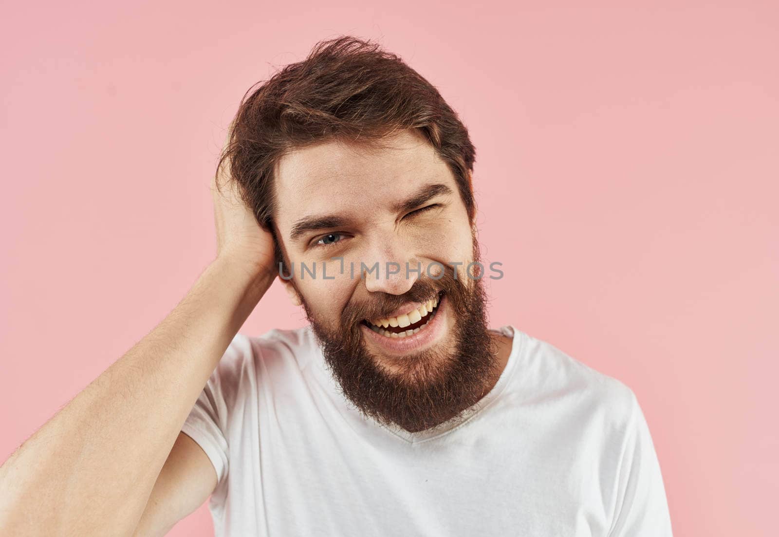 Portrait of a man with a beard and mustache on a pink background close-up cropped view. High quality photo