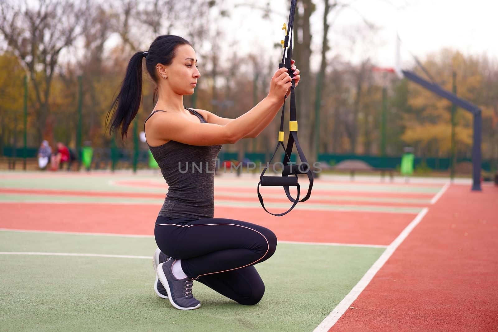 Girl athlete training using trx sportground Mixed race young adult woman workout suspension system Healthy lifestyle Stretching outdoors playground. Make your body machine