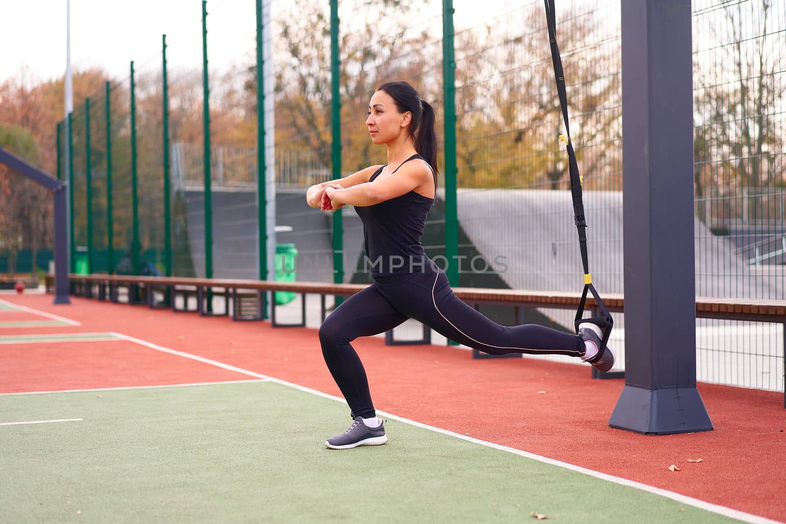 Girl athlete training using trx sportground Mixed race young adult woman workout suspension system Healthy lifestyle Stretching outdoors playground. Make your body machine