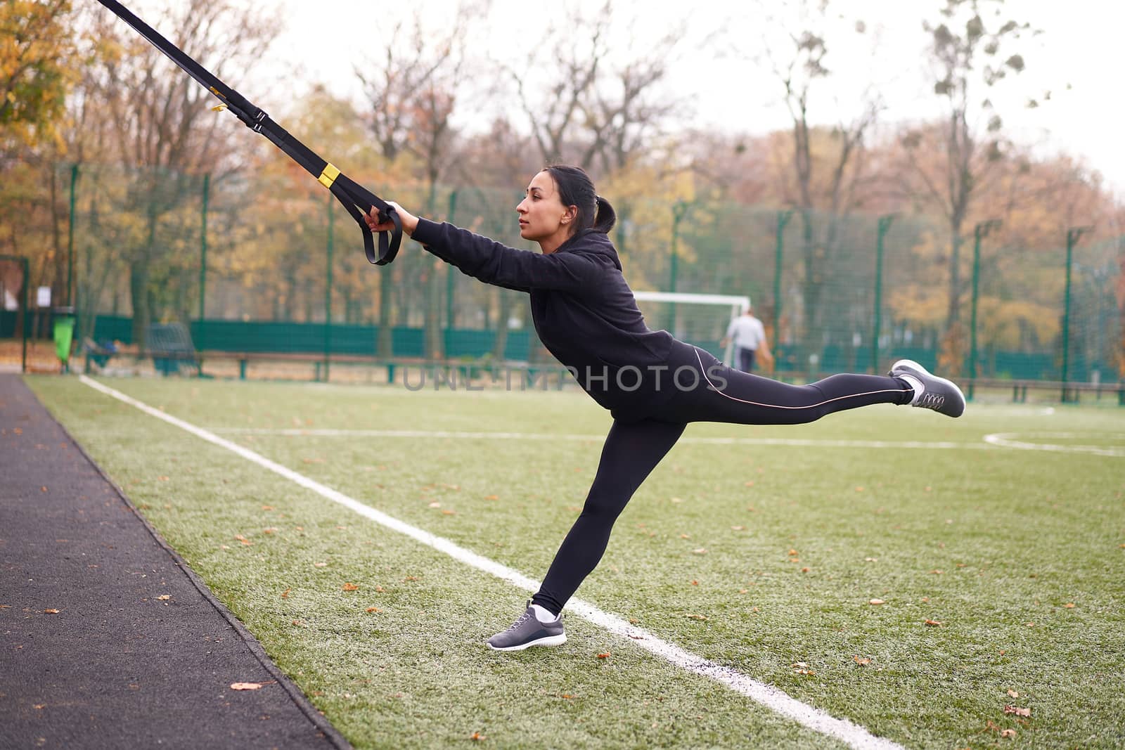 Girl athlete training using trx sportground Mixed race young adult woman workout suspension system Healthy lifestyle Stretching outdoors playground. Make your body machine