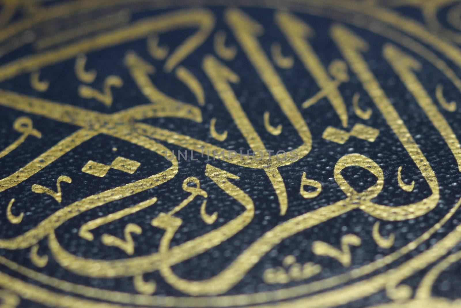 Closeup shot of Islamic Book Quran with golden arabic calligraphy by Photochowk