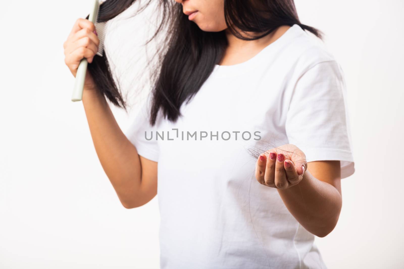 Asian woman weak hair problem her use comb hairbrush brush her hair and showing damaged long loss hair from the brush on hand, studio shot isolated on white background, Medicine health care concept