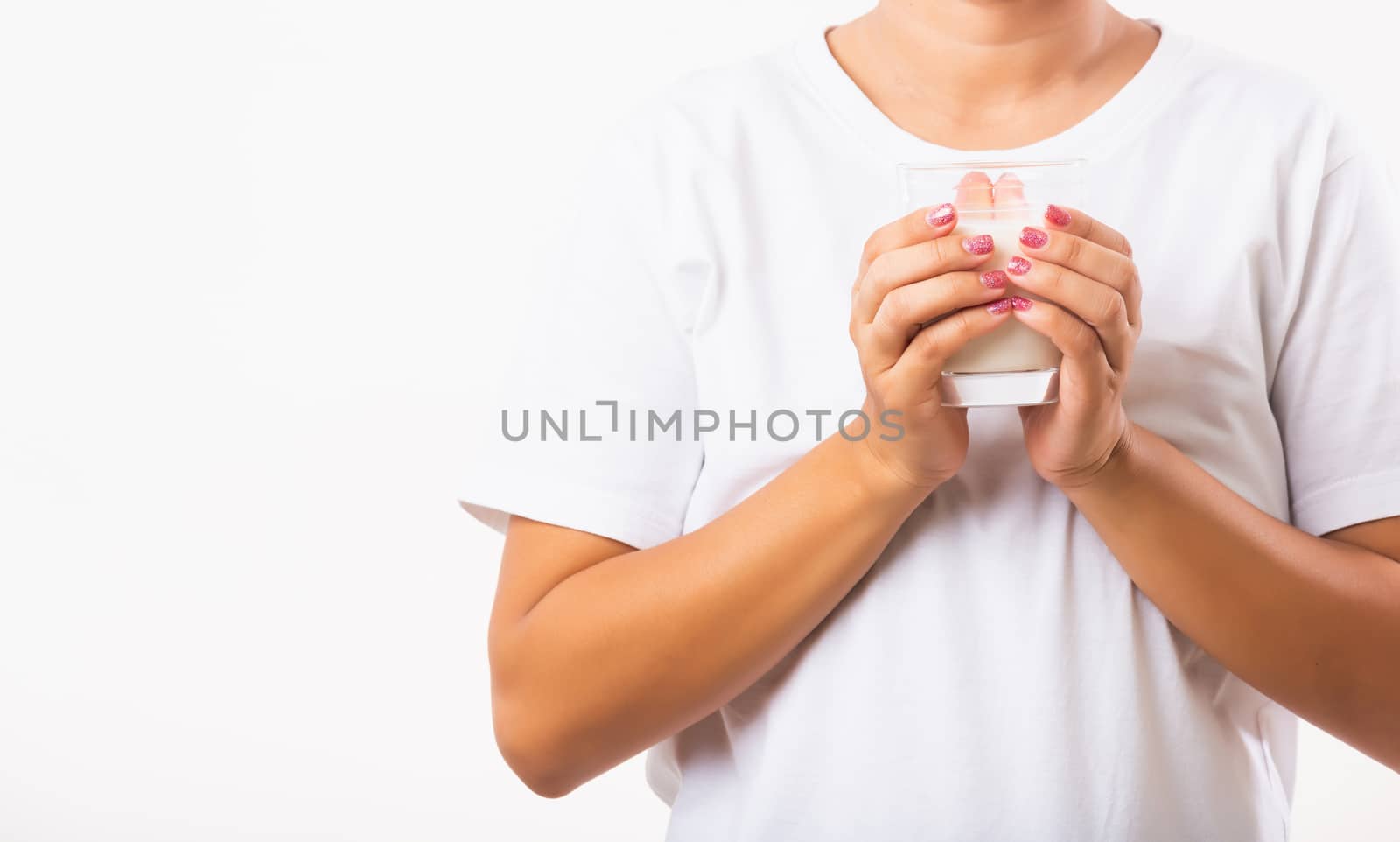 Woman use hands hold drink white milk from a glass by Sorapop