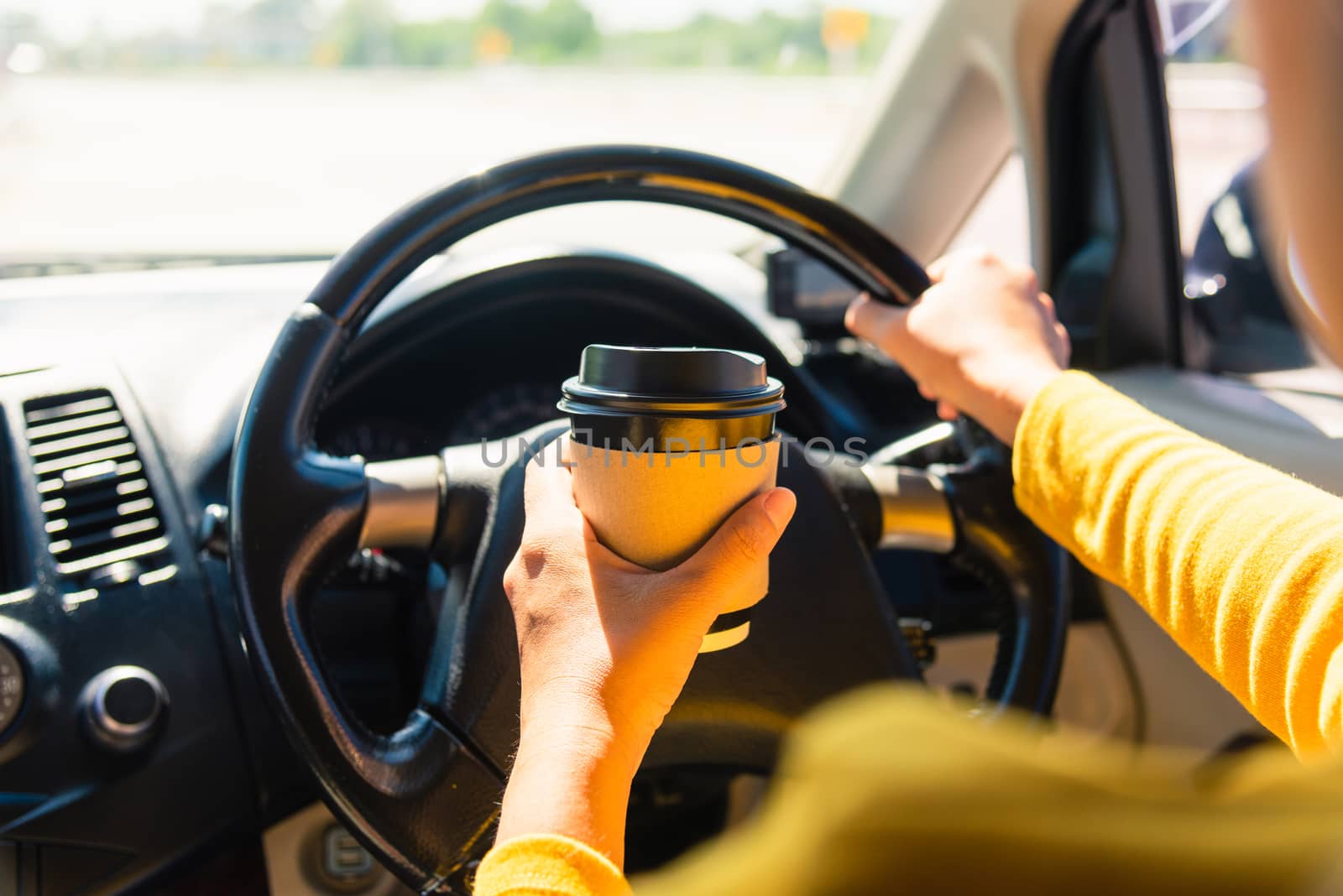 woman drinking hot coffee takeaway cup inside a car by Sorapop