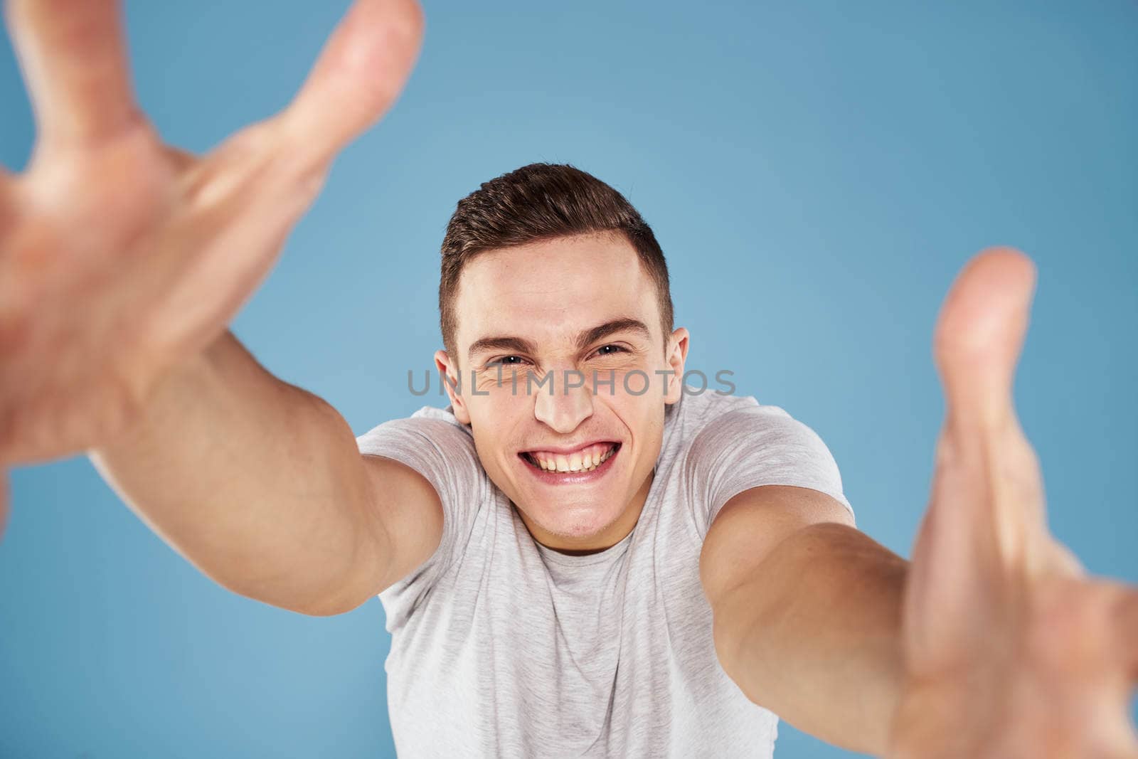 Emotional man in white t-shirt cropped view on blue background lifestyle by SHOTPRIME