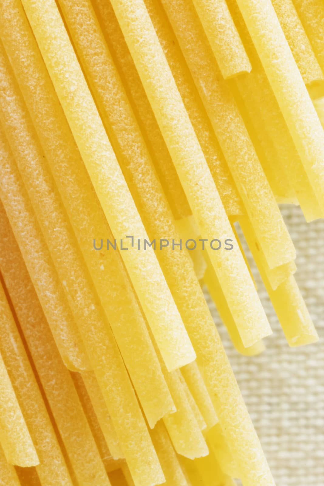 Dried pasta spaghetti  on a white background, long and thin solid cylindrical pasta , abstract effect