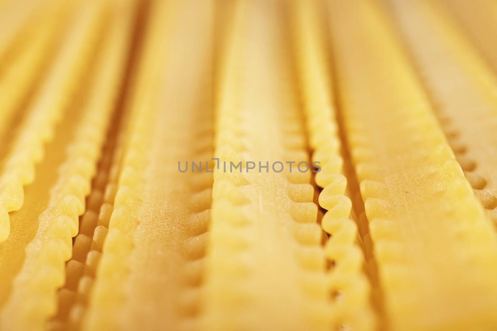 Raw Italian pasta called mafaldine  , flat and wide pasta with wavy edges on both sides  , beautiful abstract effect ,macro photography