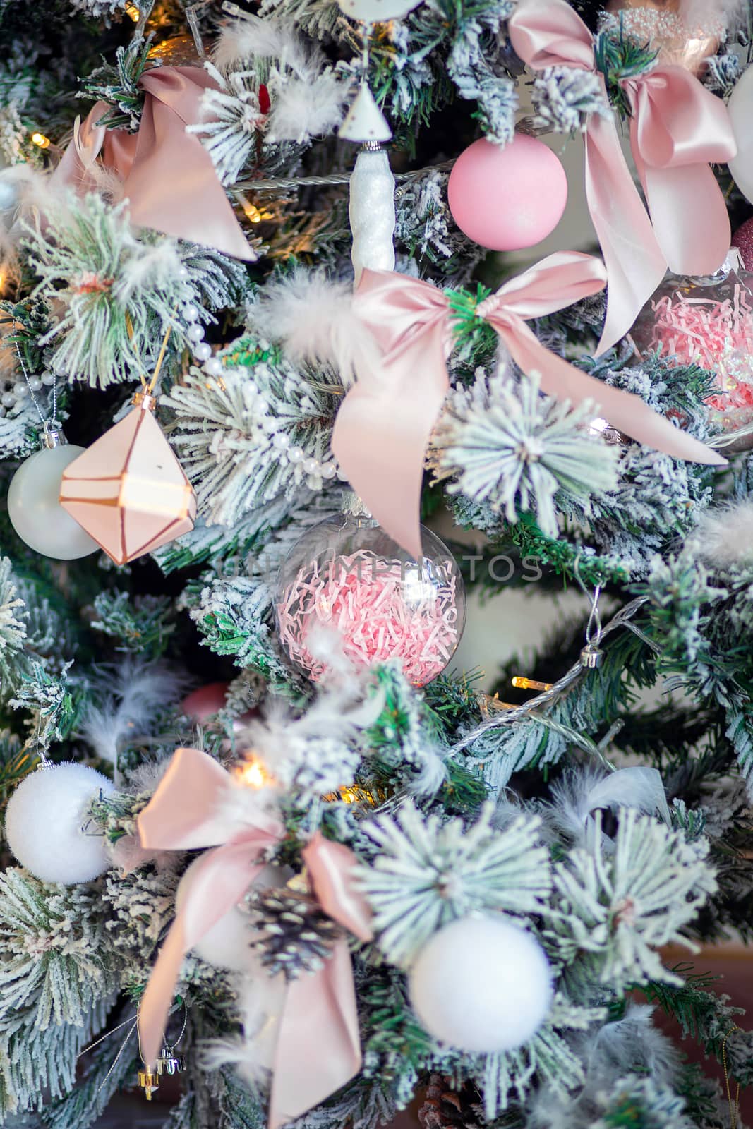 Christmas tree decoration close-up. Christmas tree decor elements. Background for postcards. Beautiful pale pink bow