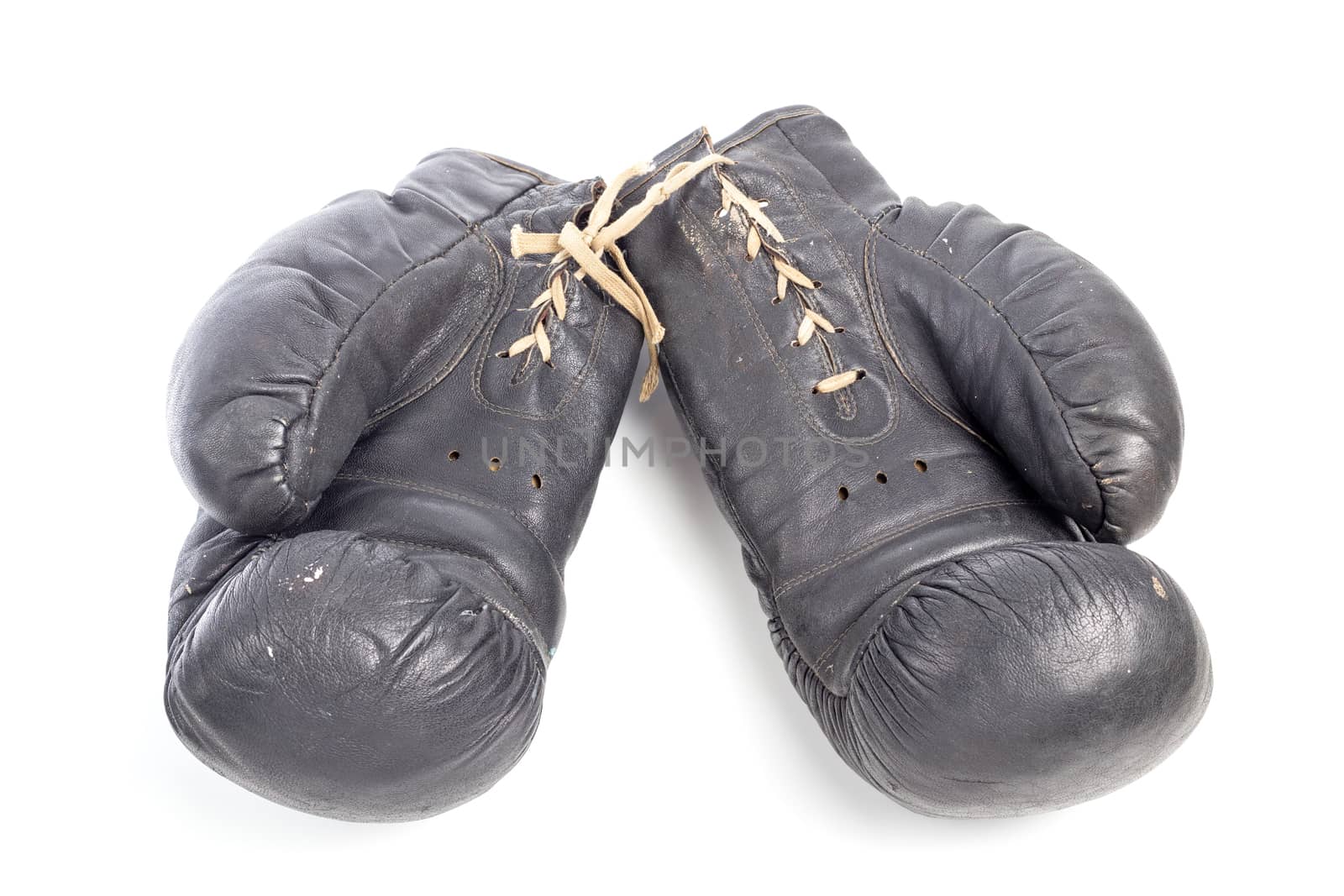 Old black leather boxing gloves isolated on white background with shadows lying on flat surface. Horsehair stuffed.