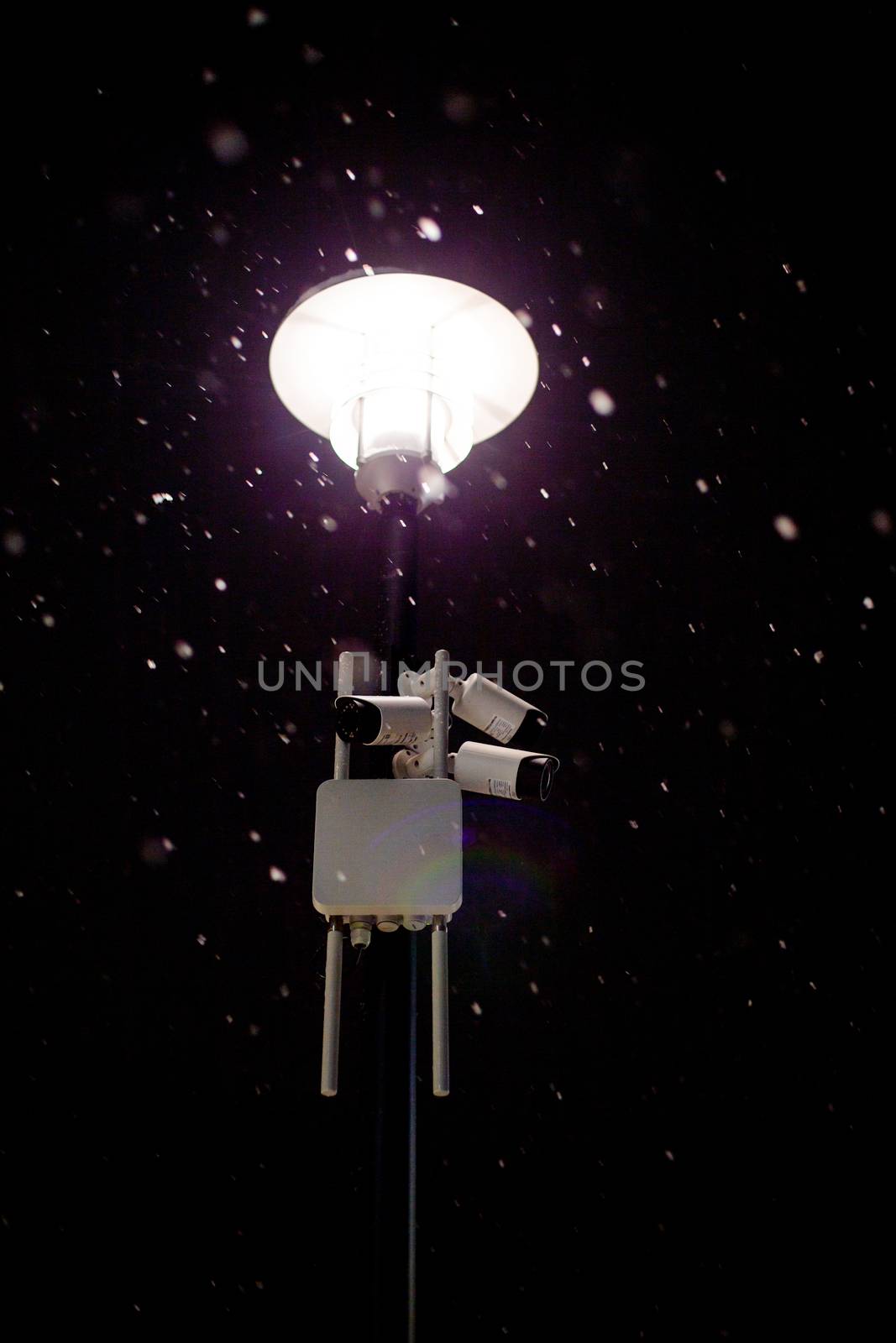 wireless cameras on night winter lamp post with snow and selective focus.