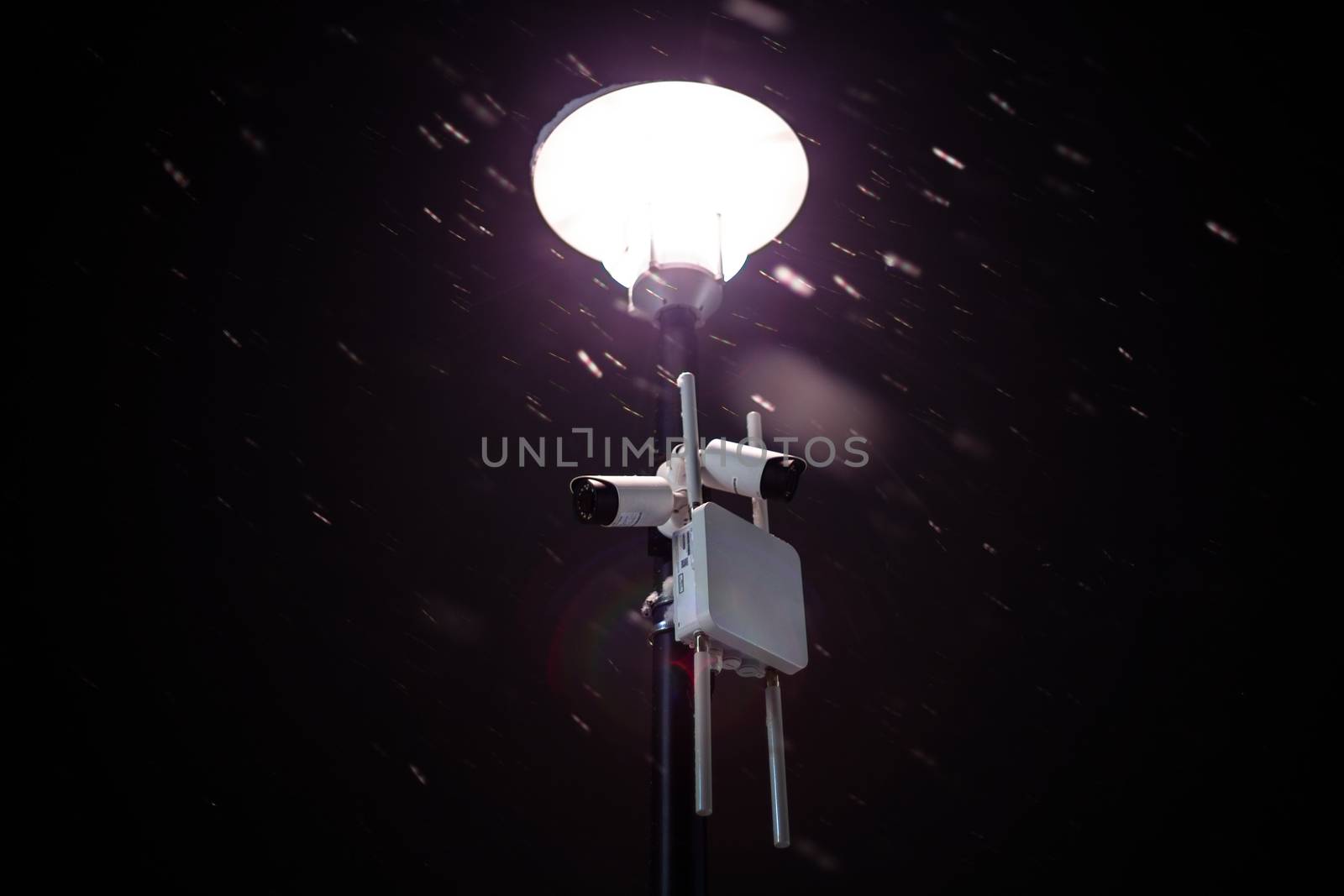 wireless cameras on night winter lamp post with snow and selective focus.