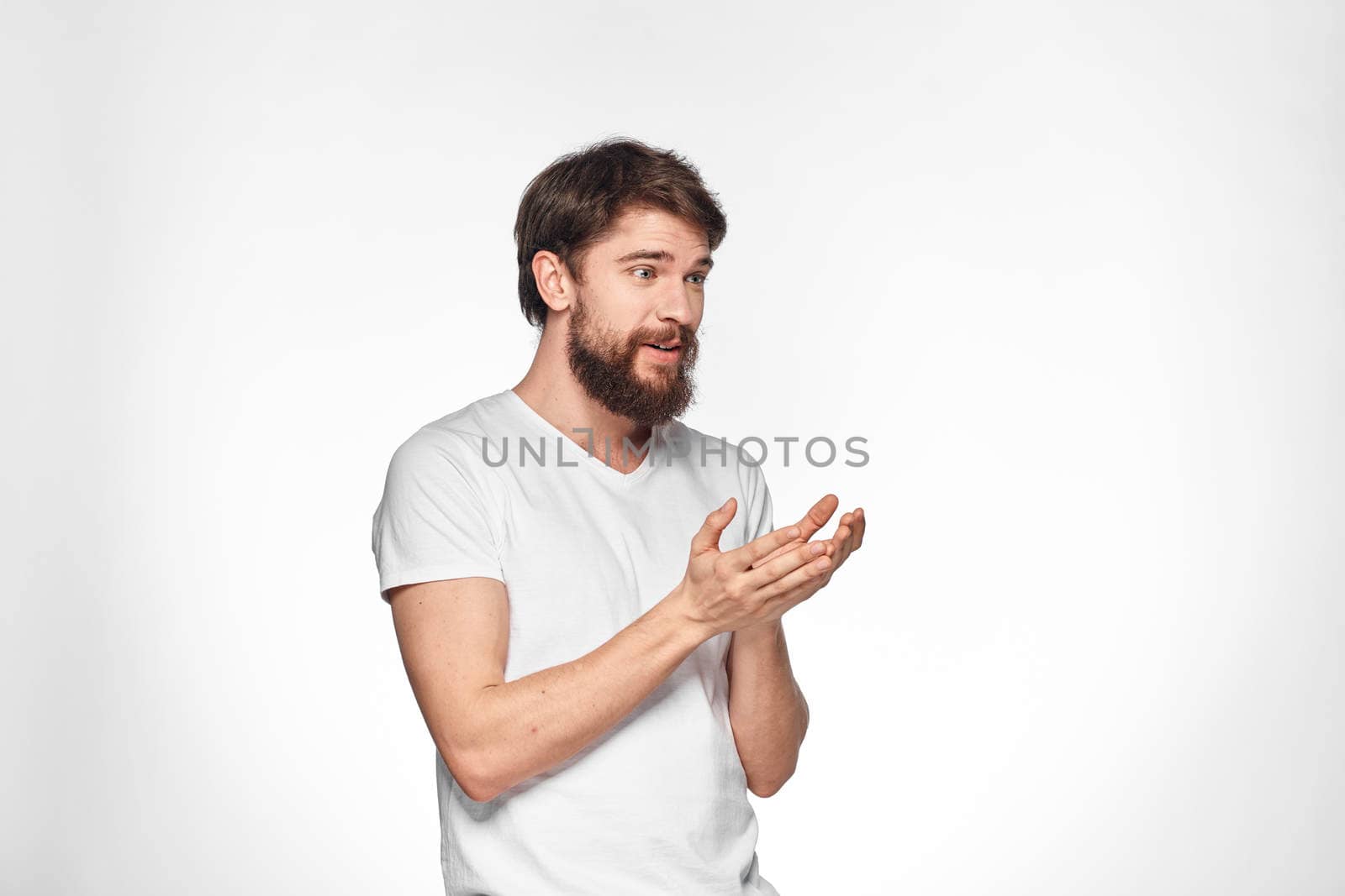 cheerful emotional bearded man gesturing with his hands close-up light background. High quality photo