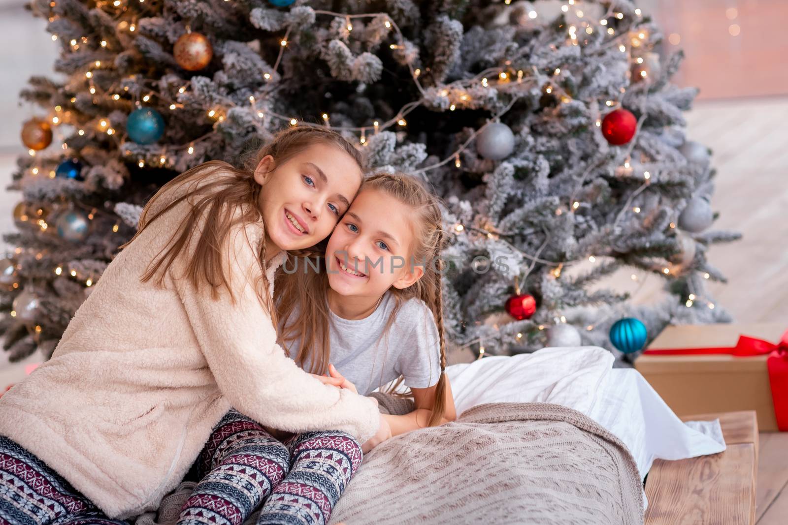 Happy kids having fun and opening presents near christmas tree.