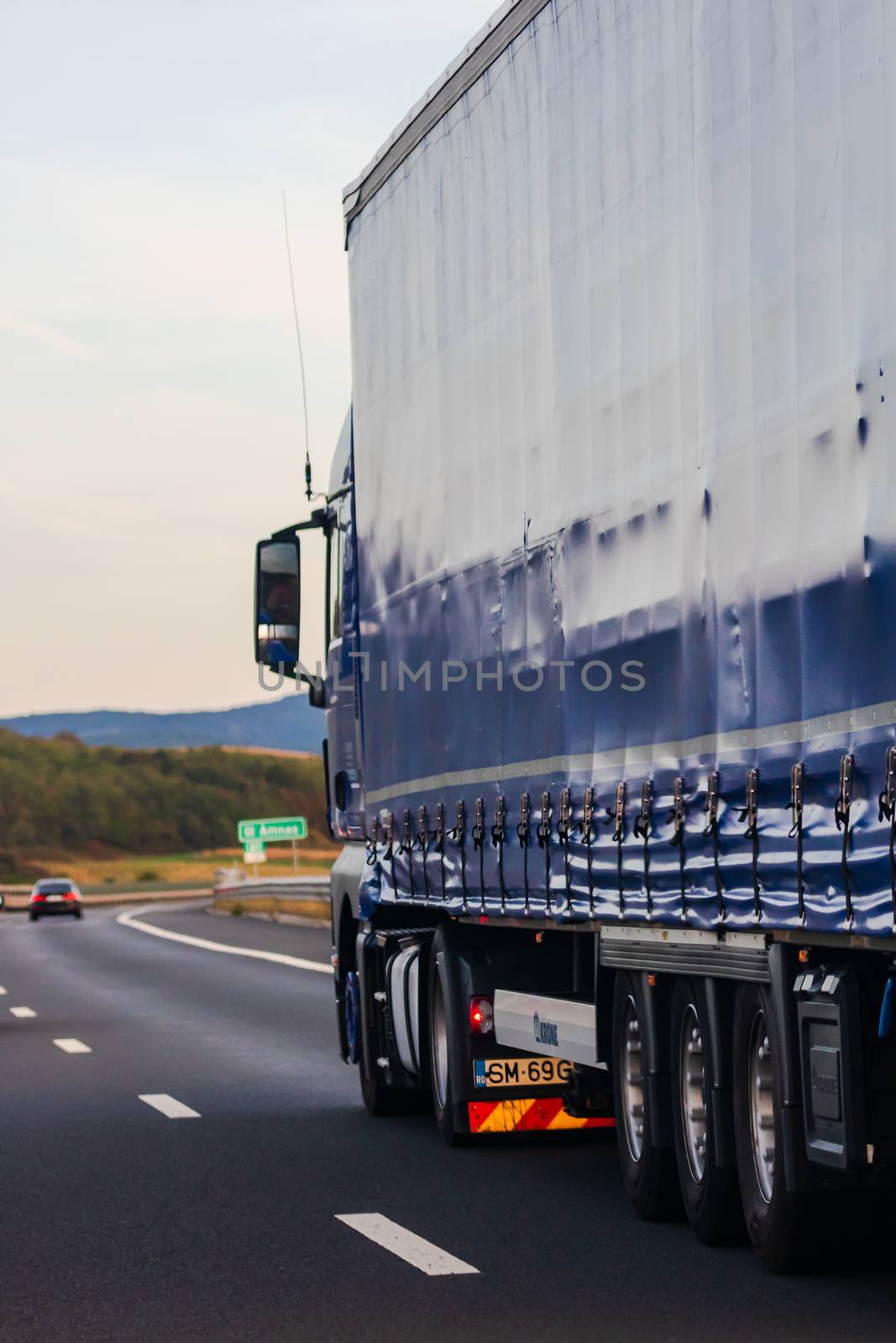 Side view of loaded European truck in motion on asphalt road, tr by vladispas