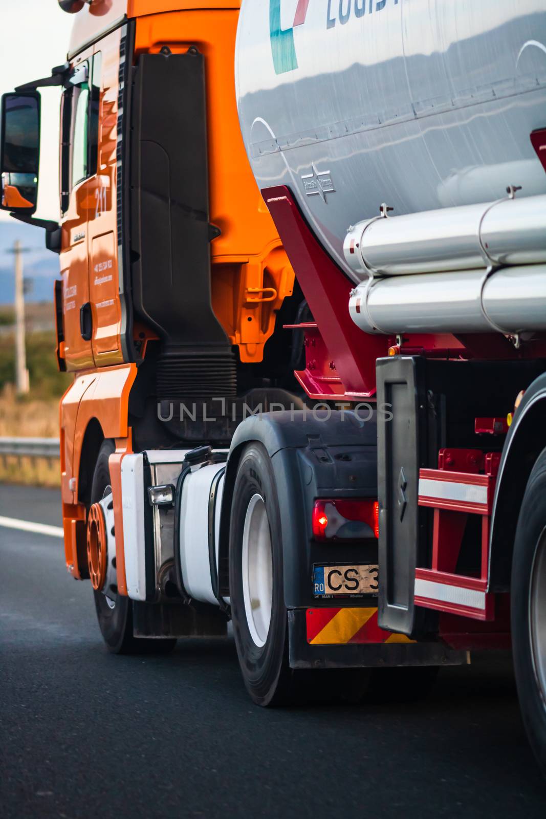 Side view of loaded European truck in motion on asphalt road, tr by vladispas
