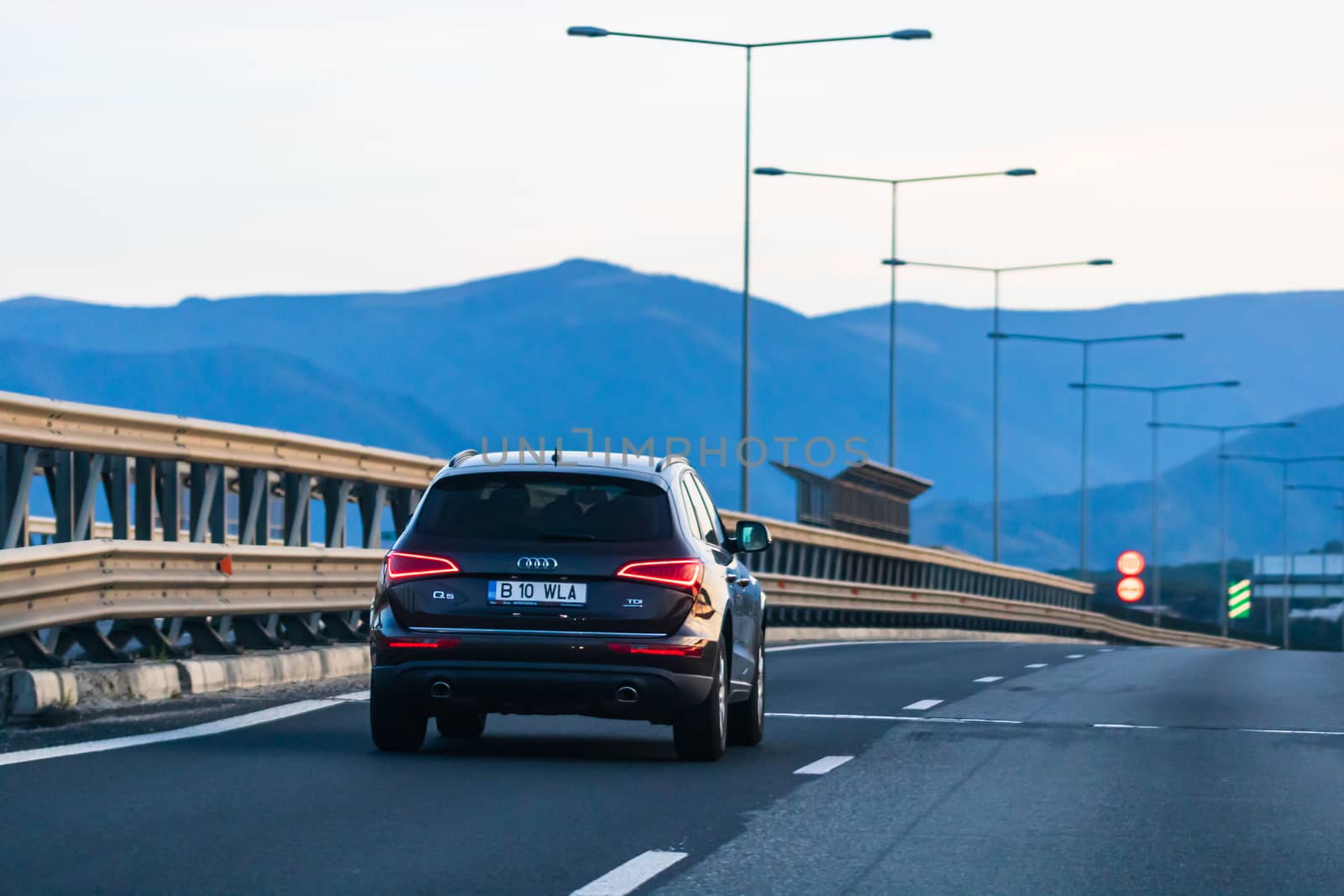 Traveling black car in motion on asphalt road, back view of car on street. Bucharest, Romania, 2020