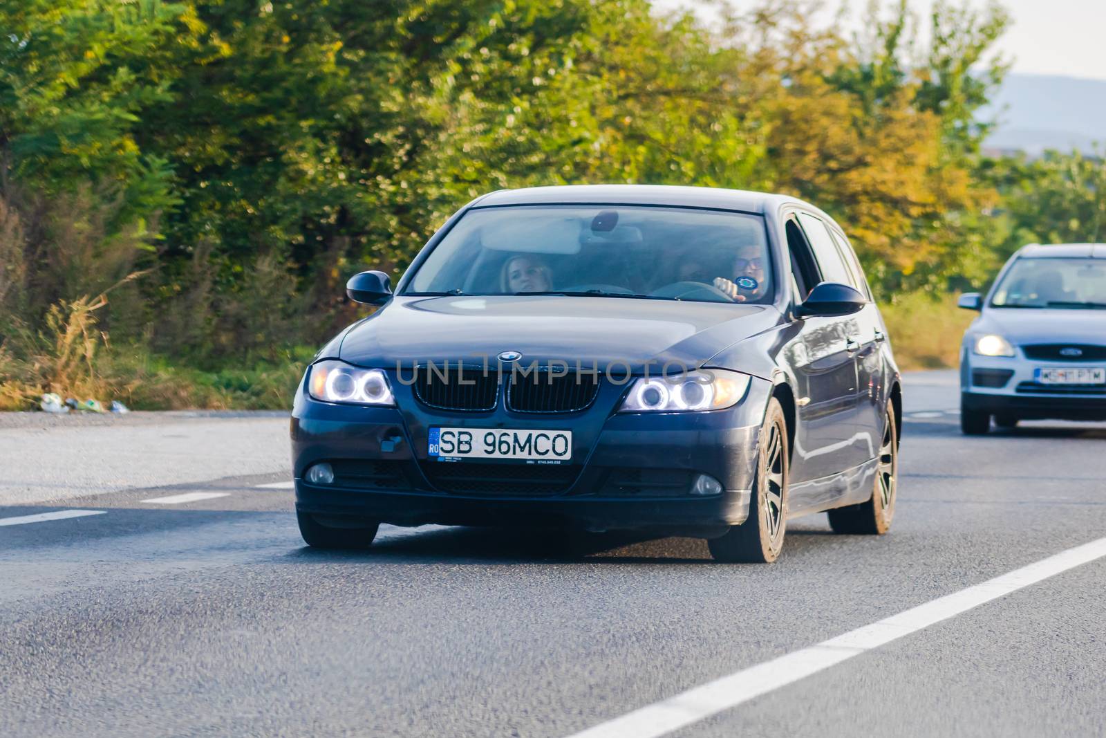 Traveling BMW car in motion on asphalt road, front view of car on street. Bucharest, Romania, 2020