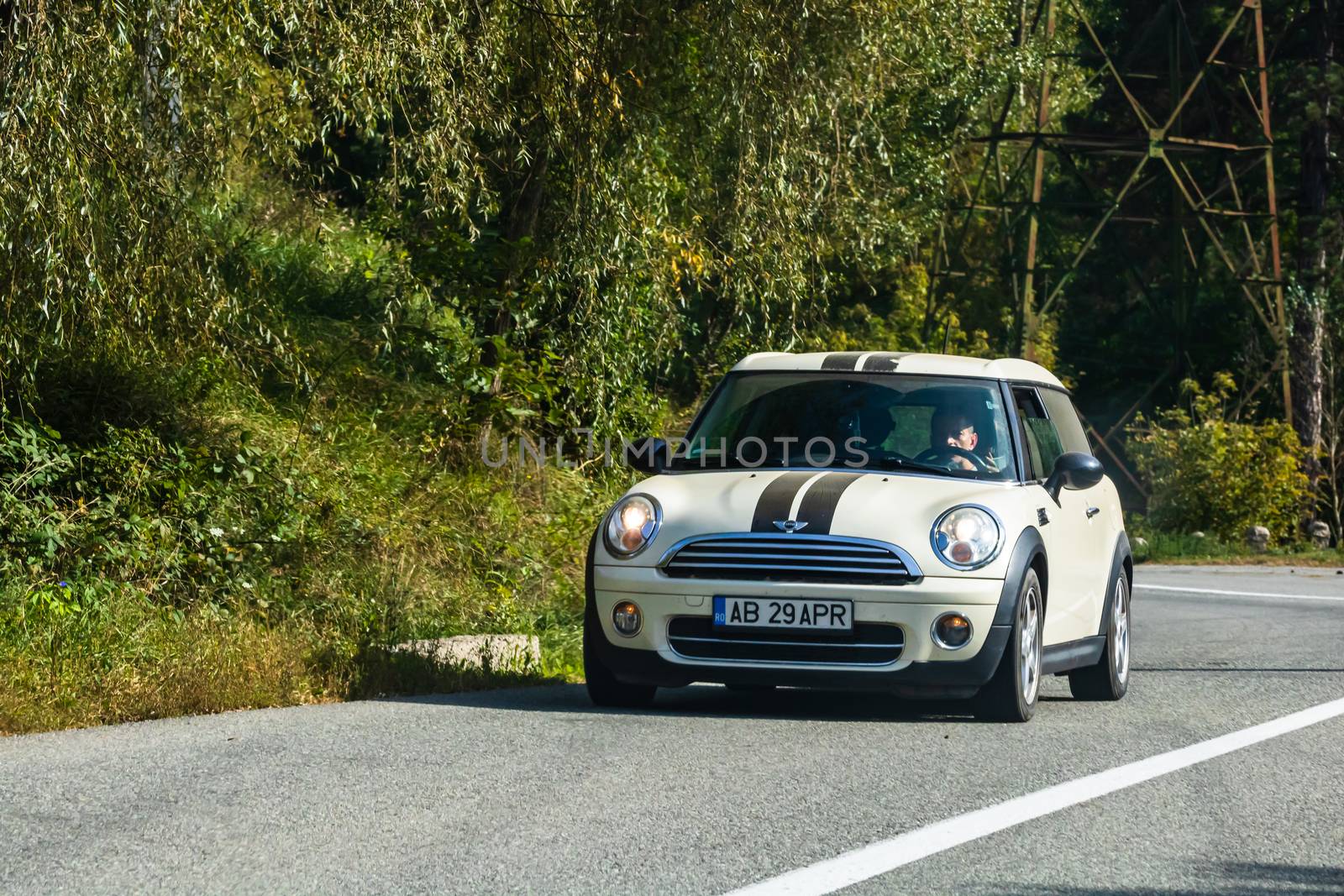 Traveling MINI car in motion on asphalt road, front view of car  by vladispas