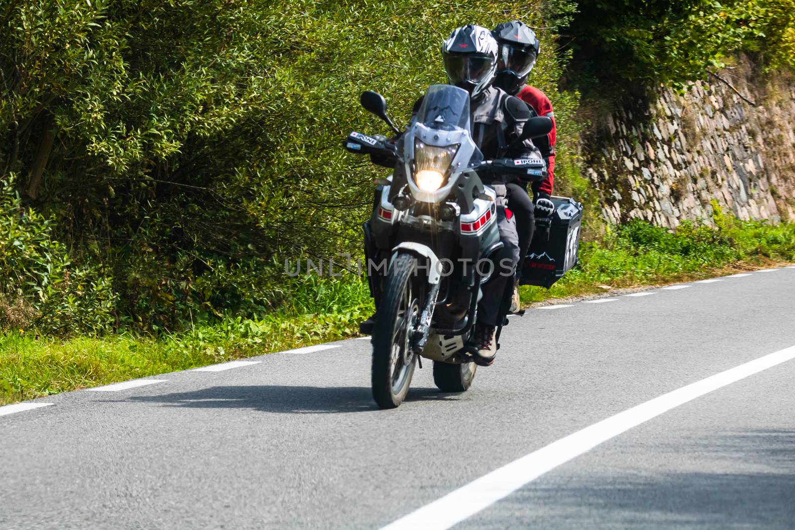 Traveling motorcycle in motion on asphalt road, front view of mo by vladispas