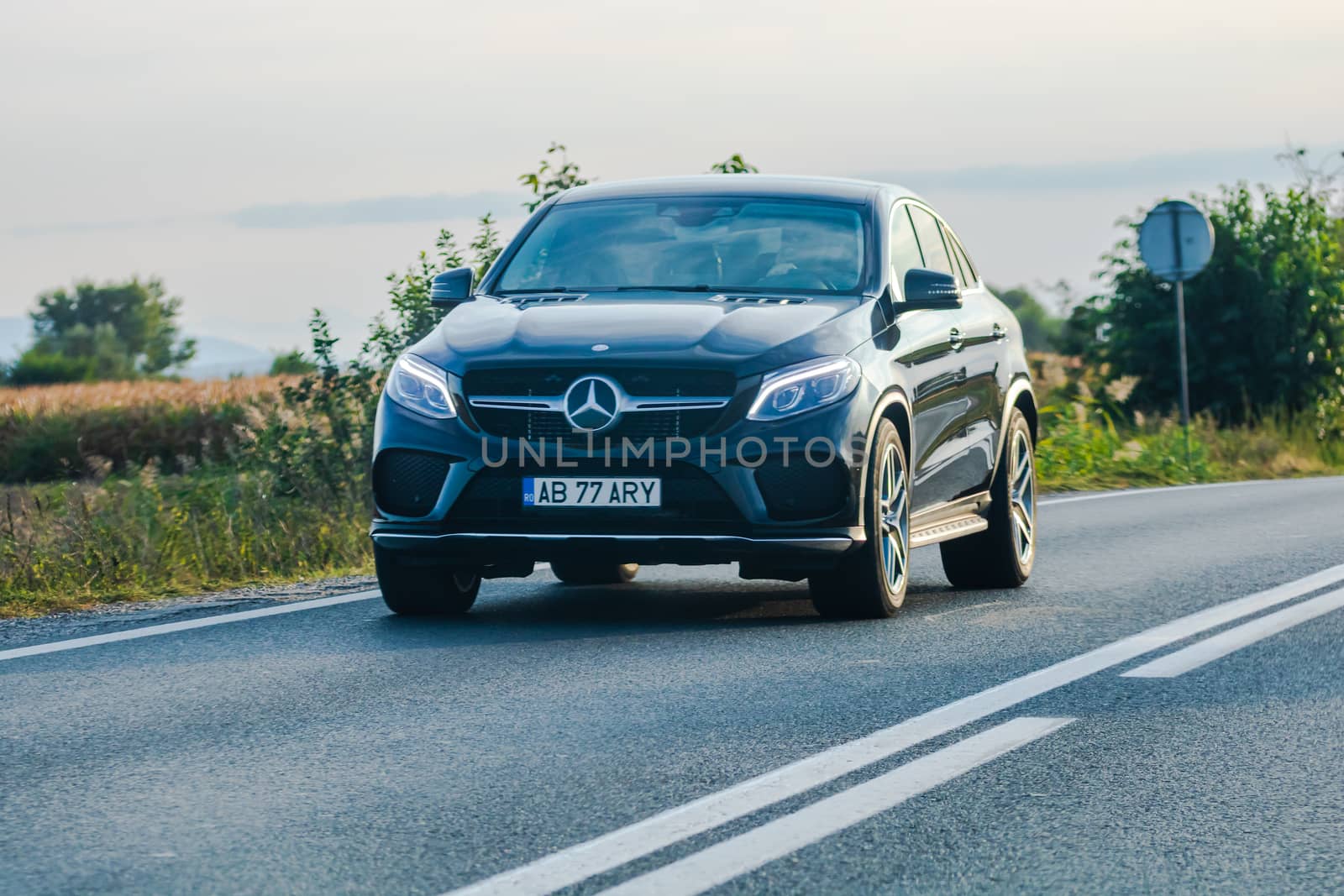 Traveling black Mercedes car in motion on asphalt road, front view of car on street. Bucharest, Romania, 2020