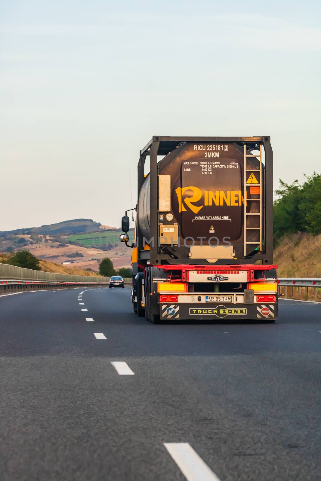 Back view of loaded European truck in motion on asphalt road, transportation and delivery concept. Bucharest, Romania, 2020