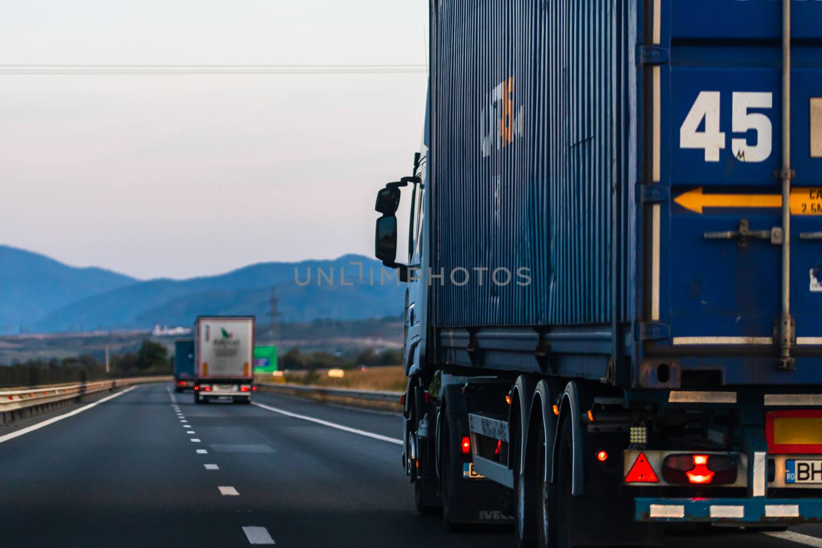 Side view of loaded European truck in motion on asphalt road, tr by vladispas