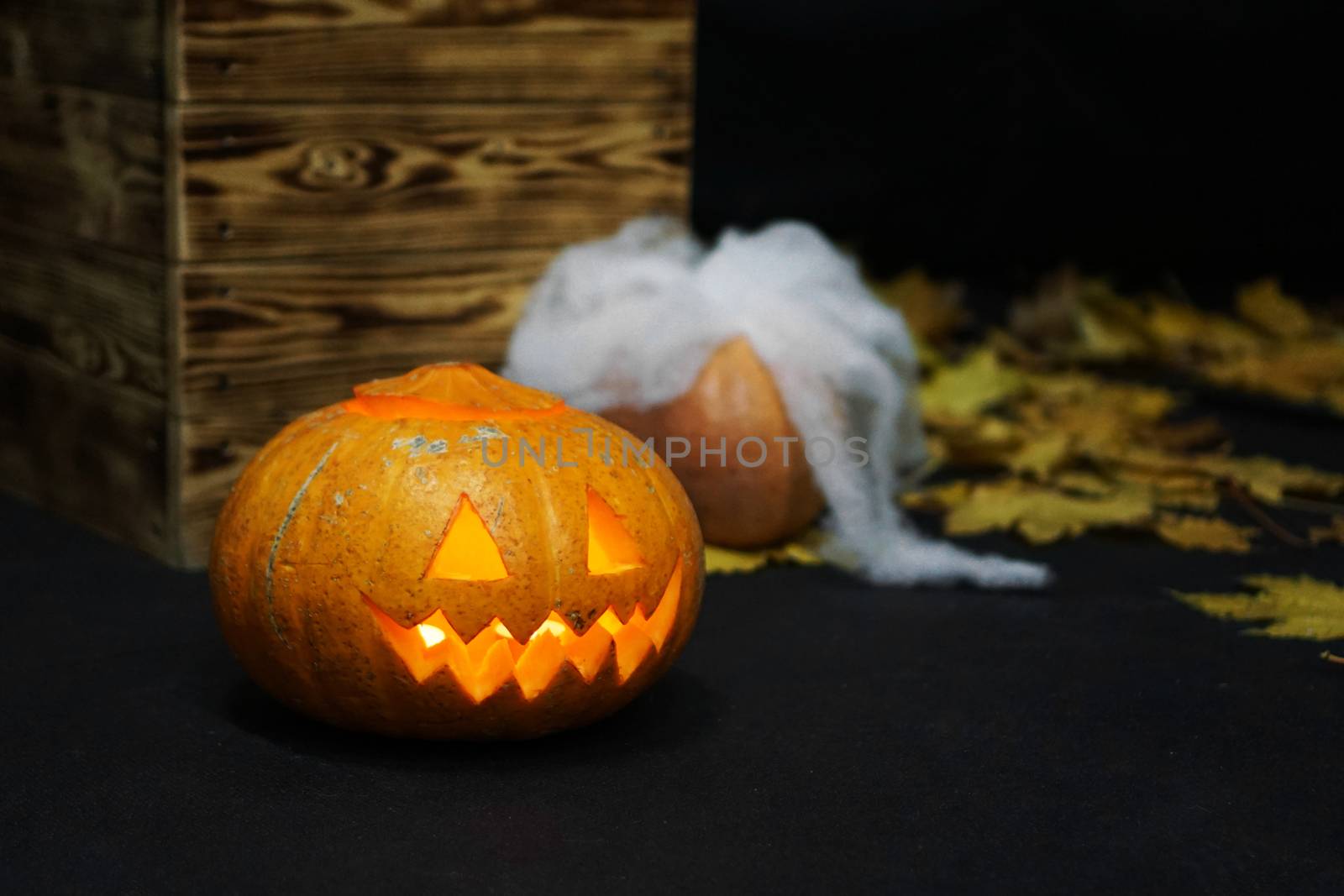 Halloween Pumpkin with fire in front of spooky dark background.