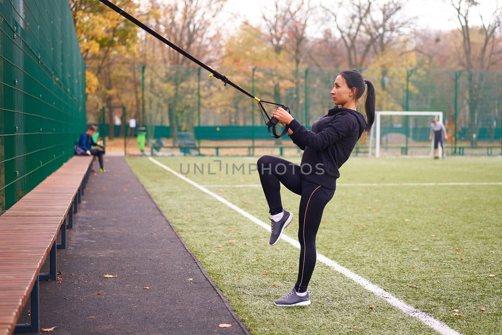 Girl athlete training using trx sportground Mixed race young adult woman workout suspension system Healthy lifestyle Stretching outdoors playground. Make your body machine