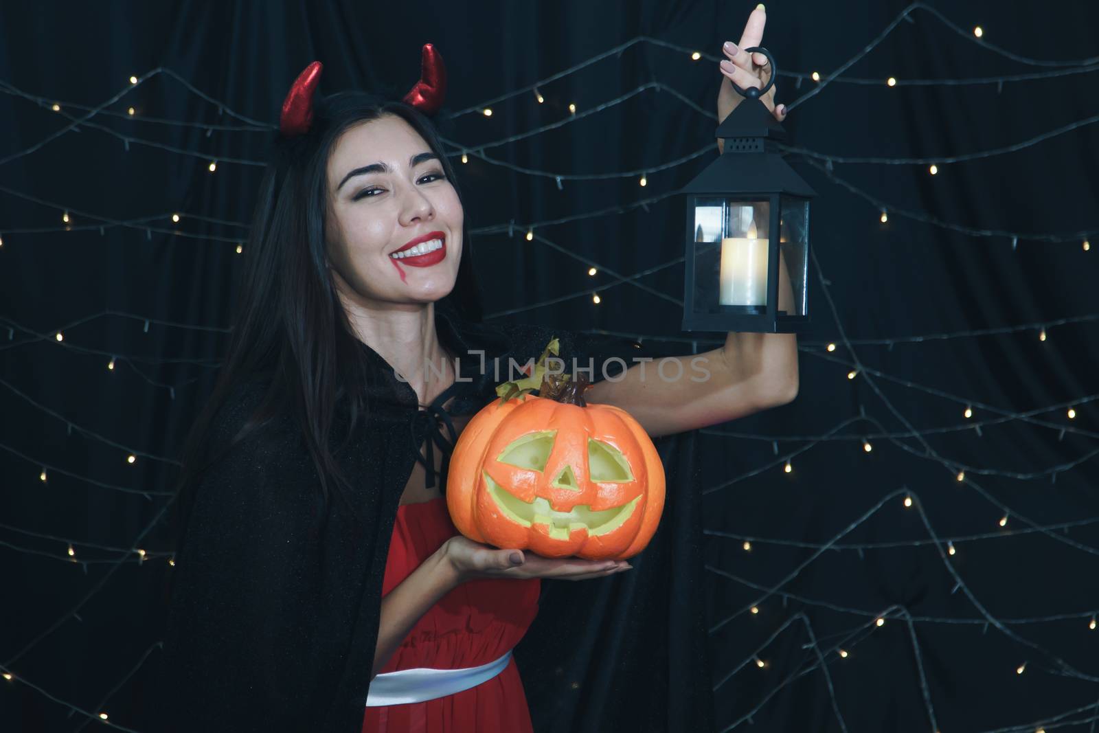 Beautiful witch with carved pumpkin on Halloween. by nuad338