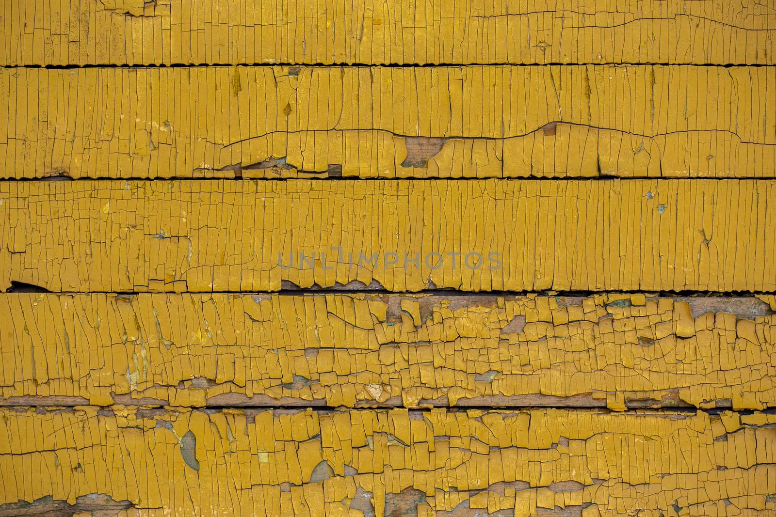 Yellow color painted weathered wooden horizontal planks texture with vertical craquelures