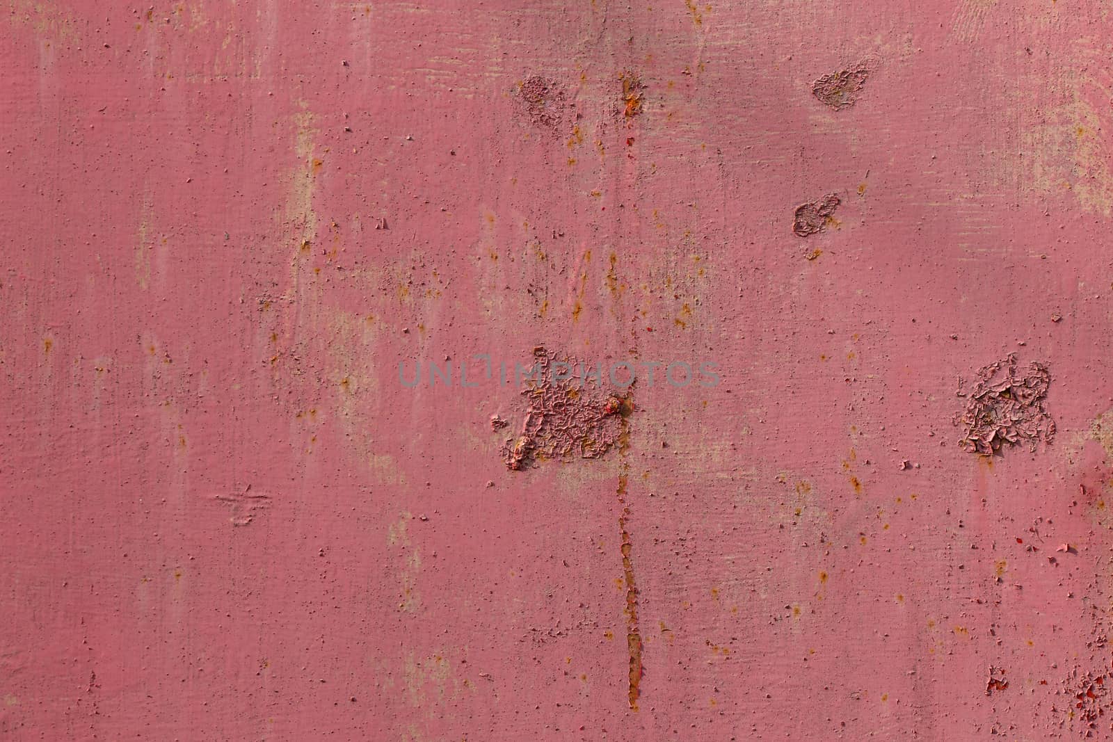 Weathered pink painted metal wall. Abstract background and rough texture.